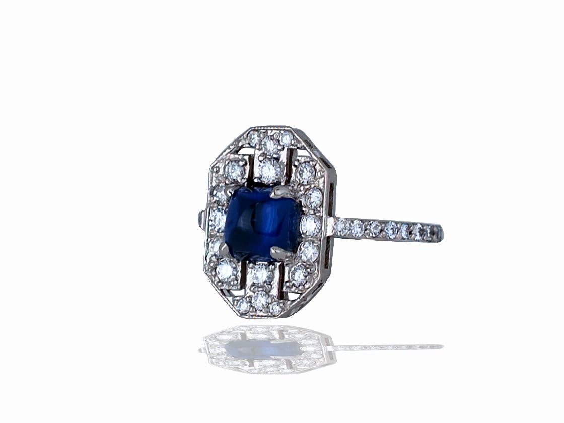 This ladies sapphire and diamond shield ring contains the following.  One blue sapphire which is a sugar loaf cabochon that measures 5.5 x 5.5 x 5.7 mm.  The center stone has a rich blue color with some silk that can be seen under magnification. 