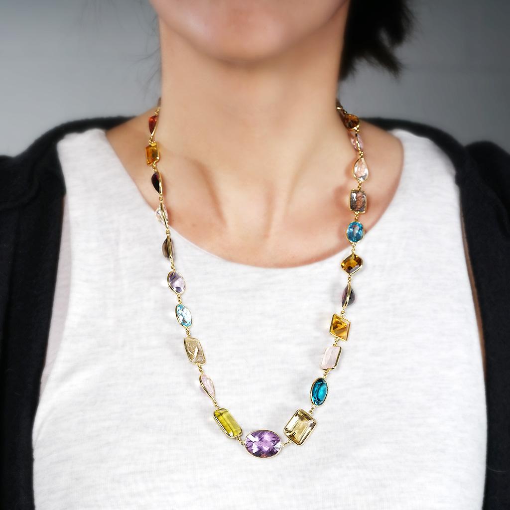The necklace is 25 inches in length, made of 18K yellow gold, and weighs 35.80 DWT (approx. 55.68 grams). It also has 28 mixed shapes multi colored stones, two mixed shapes smoky quartz's, two mixed shapes peridots, five mixed shapes rutilated