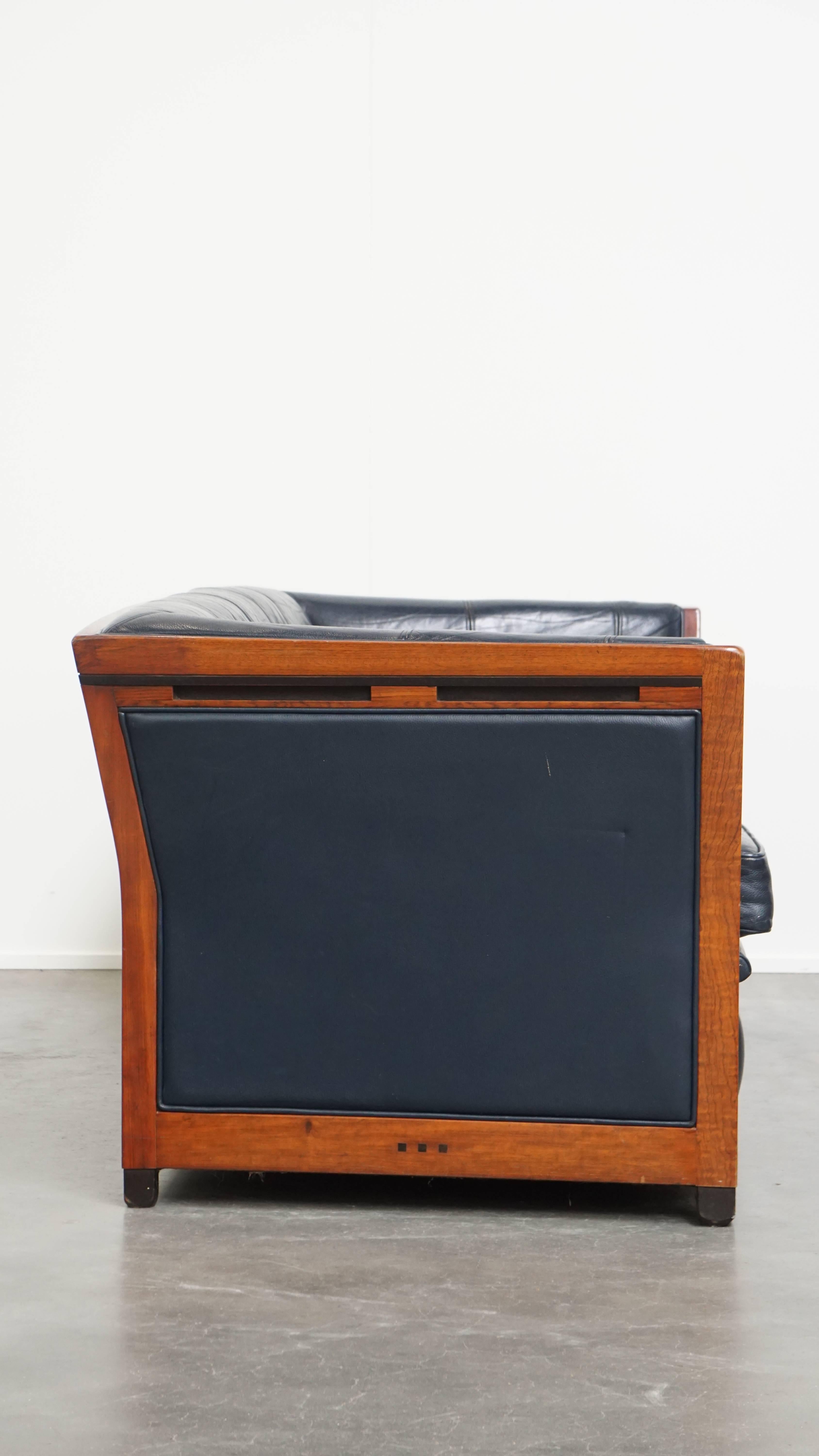 Questo elegante divano a 2,5 posti dal design Art Déco di Schuitema è caratterizzato da un'elegante lavorazione del legno e da una pelle di vacchetta blu scuro.
Questo bellissimo pezzo è realizzato dal rinomato marchio olandese Schuitema, noto per