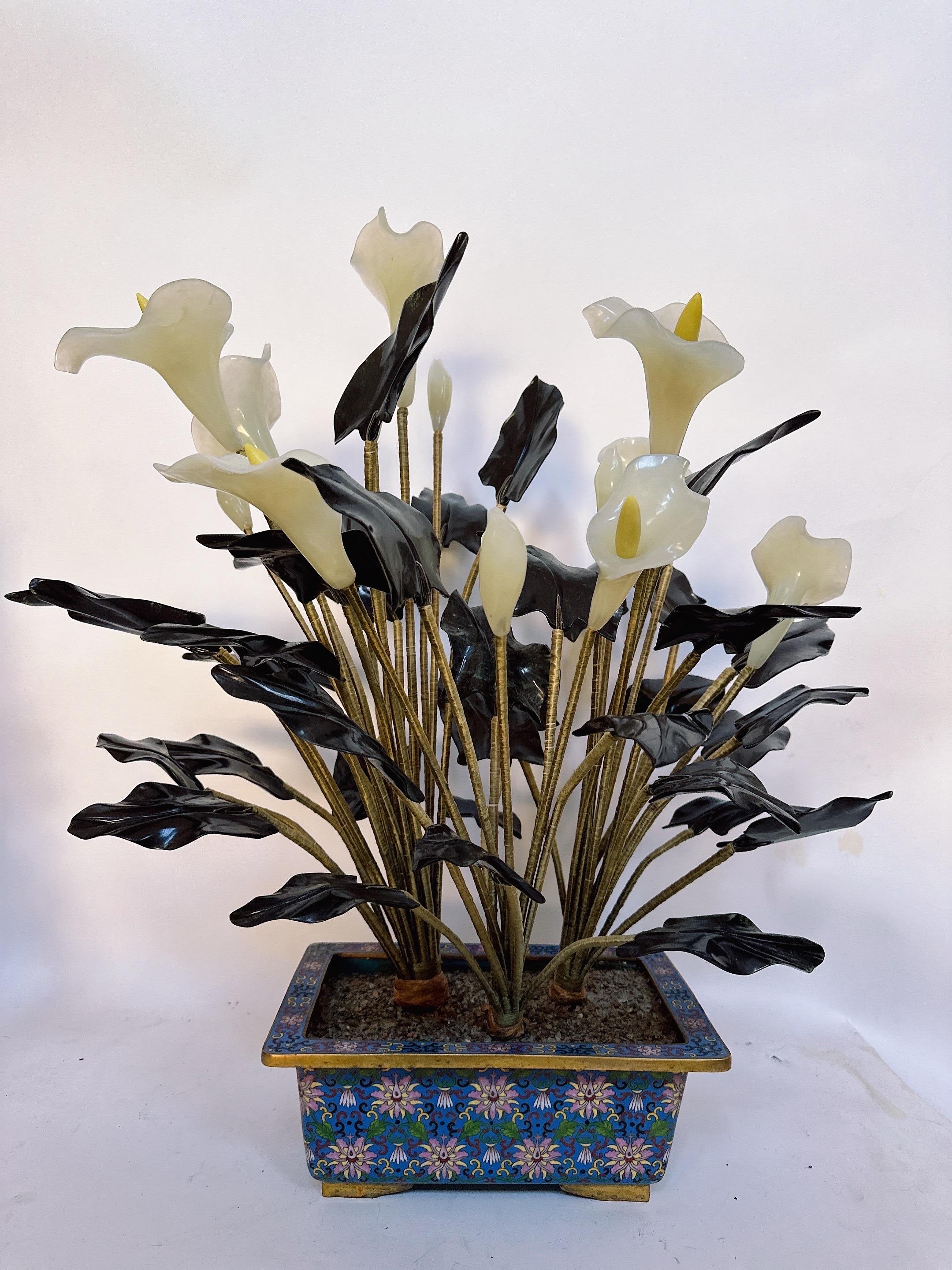 A unique 25'' Chinese Jade floral tree composed of metal bending arms supporting spinach green Jade leafs and White Jade Alocasia flowers, sits inside a beautifully decorated gilt cloisonne blue lotus flower motif planter.
 Circa: late 19th to