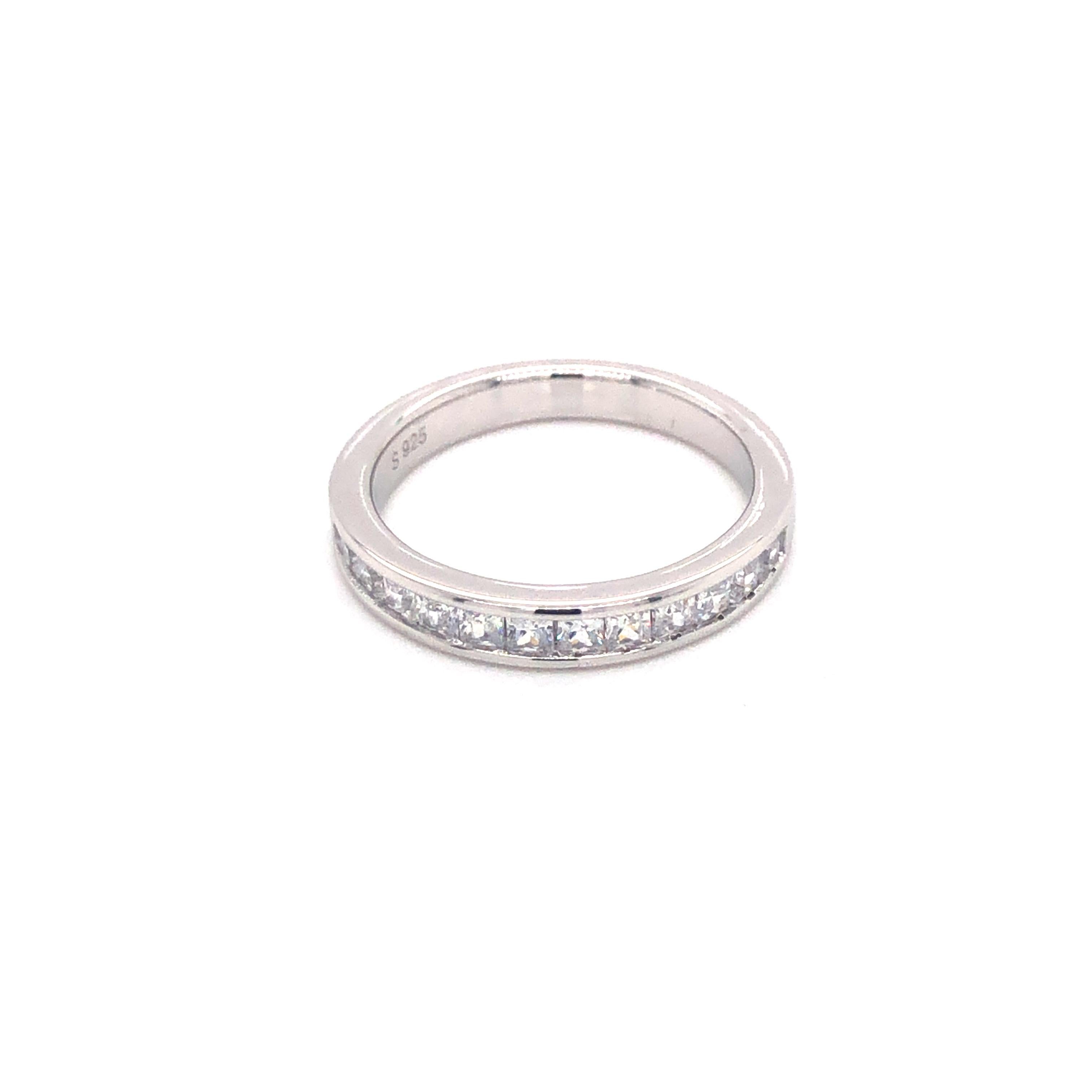 This versatile channel set princess cut band ring can be worn alone or complement any solitaire. The stunning simplicity of this design will take you effortlessly from desk to dinner. 

Featuring 12.50ct princess cuts, set into a half eternity band,