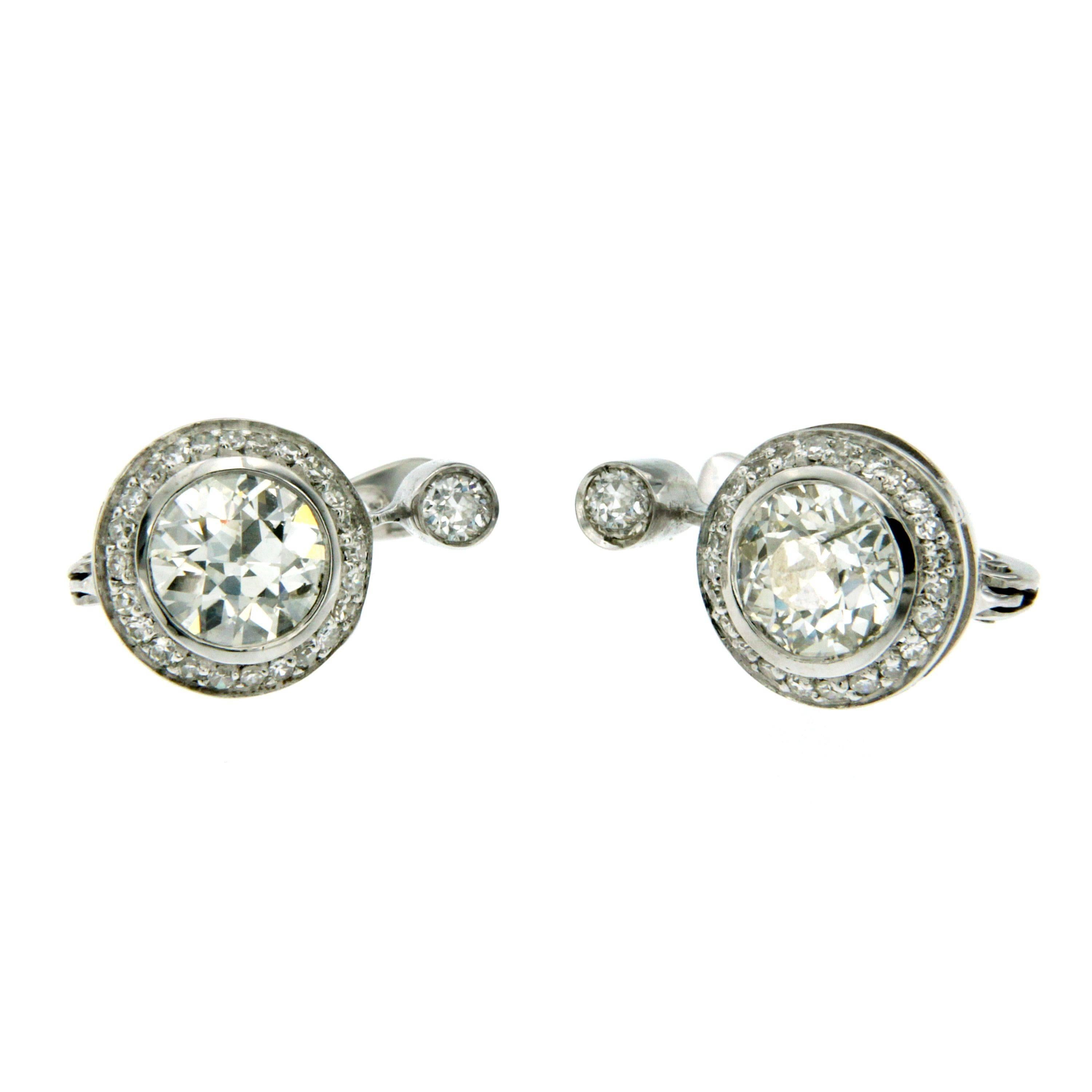 18k white Gold drop earrings consisting of 2 Old mine cut diamonds having a total weight of approximately 1,80 carats I color P  clarity, combined and topped with 0.20 carats of old mine cut diamonds G-H color; all surrounded by small brilliant cut