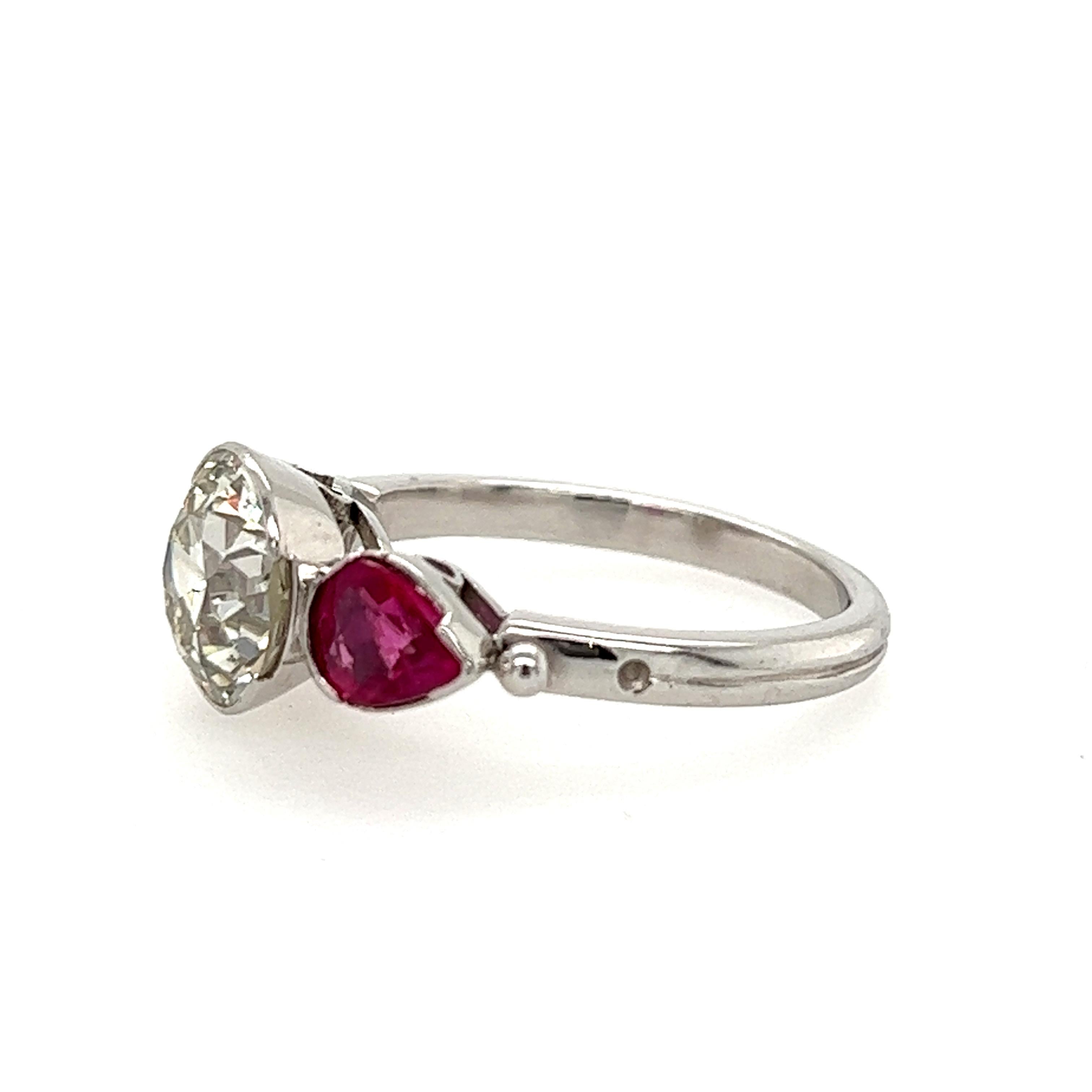 2.50 carat European cut diamond ring with ruby side stones in platinum. The center diamond measures 8.50x5.65mm and has K-L Color and SI1 Clarity. There are a pair of pear shape Rubies flanking the diamond on either side weighing 1.40 carats total.