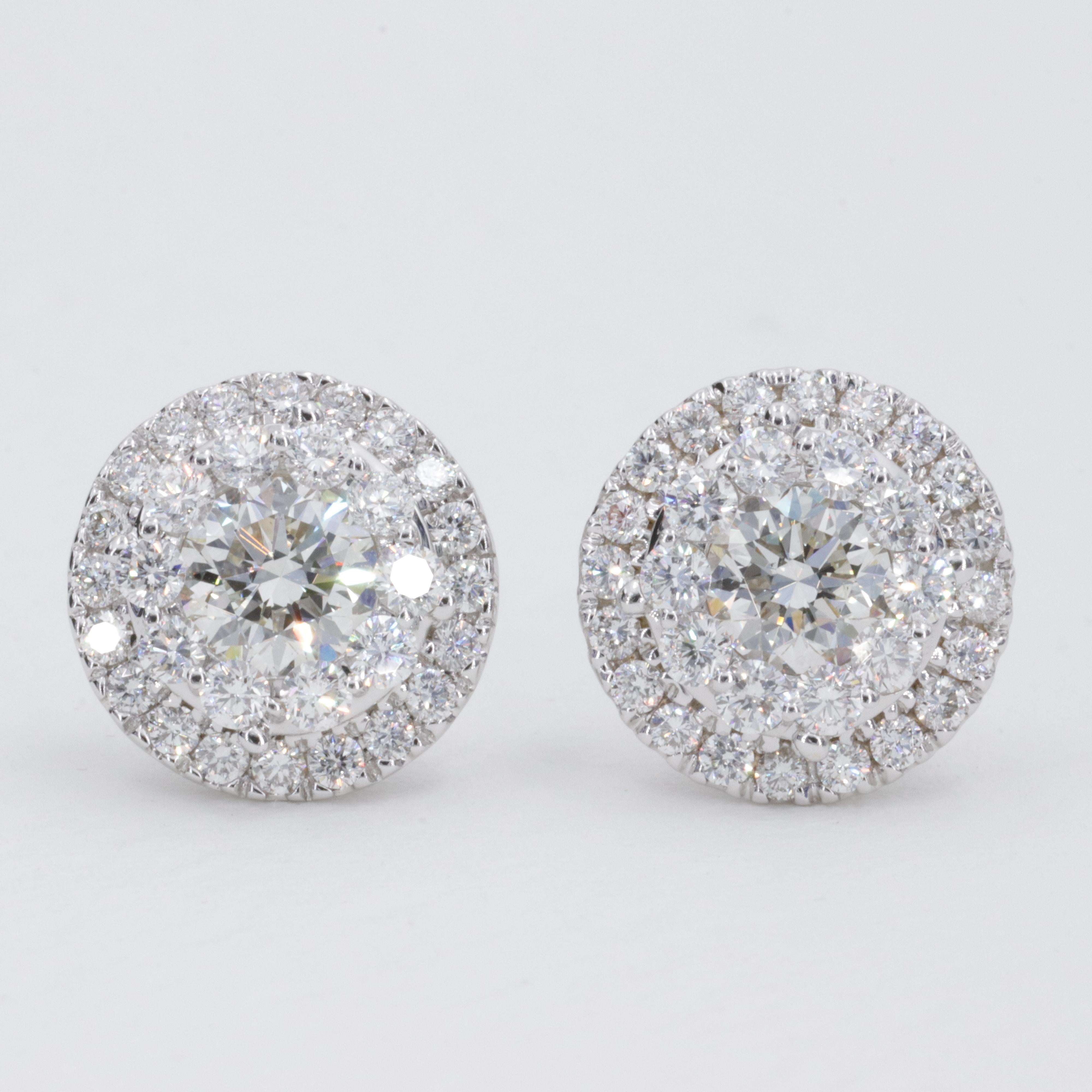 A beautiful pair of round brilliant cut natural diamond halo stud earrings weighing approximately 2.50 carats. The diamonds are finely cut and proportioned and give off an incredible brilliance. 

The center diamonds are uniquely set behind the