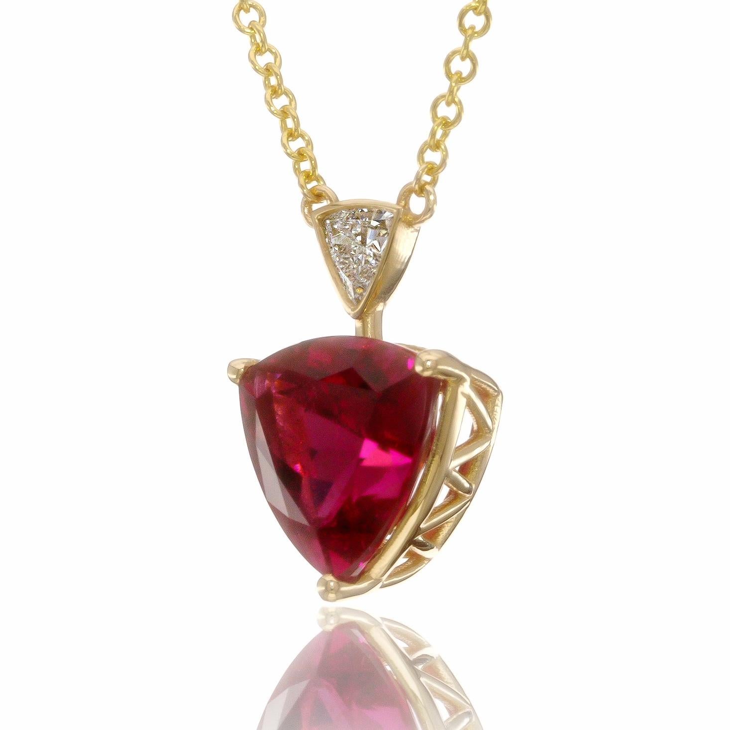 This 14K yellow gold pendant featuring a stunning rubellite gemstone is truly extraordinary. The gemstone, known for its vivid pink to red hues, is cut into a distinct triangular shape, resembling a triangle. This unique cut, often referred to as a