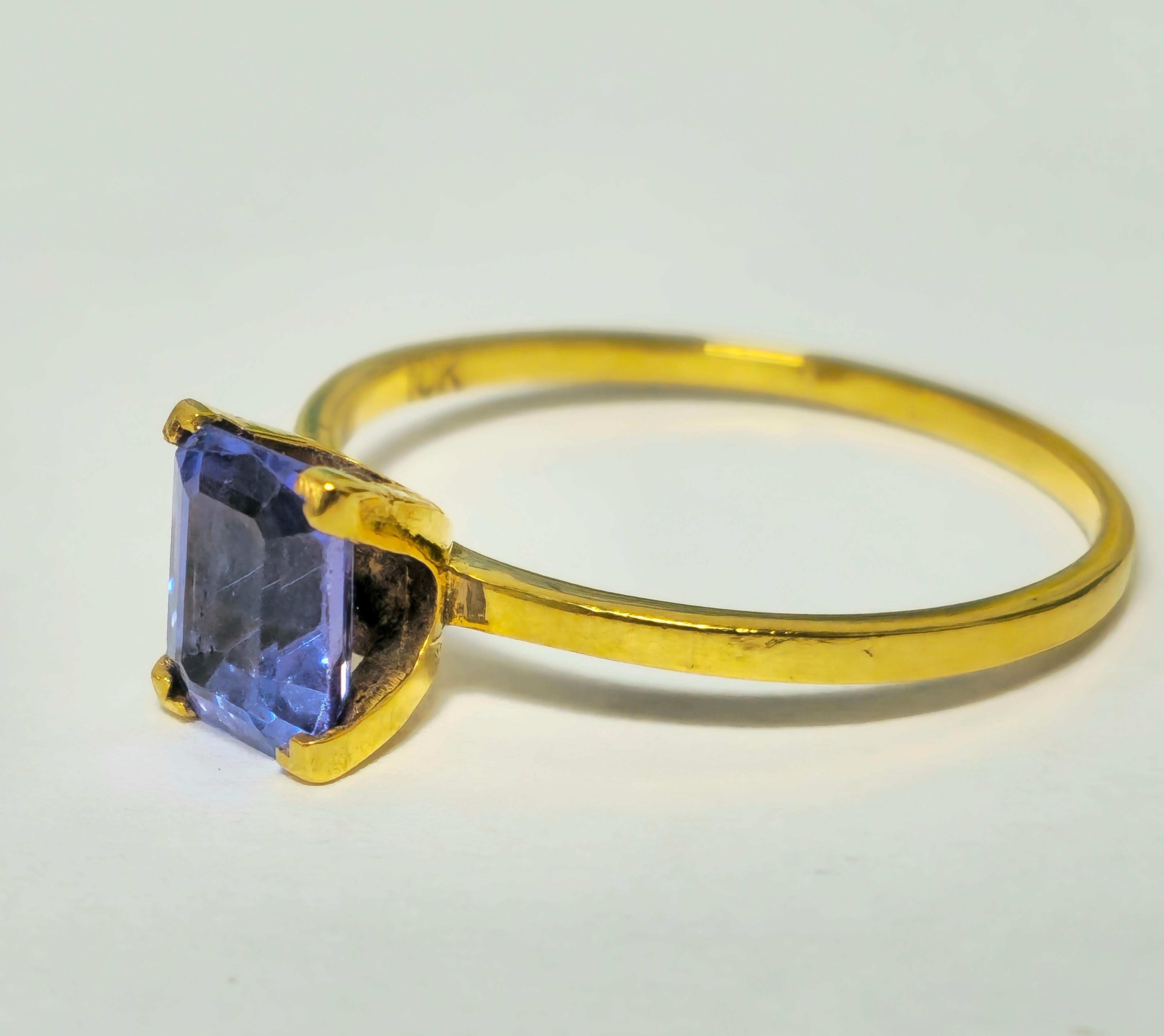 Fashioned from 10k yellow gold, this collectible ring showcases a stunning 2.50 carat emerald-cut Tanzanite gemstone, boasting excellent color and saturation. Weighing 2.10 grams, it offers a comfortable fit for US size 10, with complimentary ring
