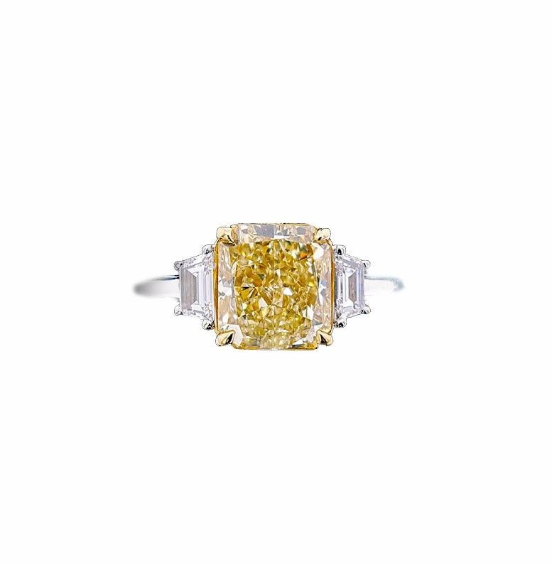 Impresionante anillo de compromiso con un diamante Amarillo Fancy Natural de 2,57 quilates, talla radiante, certificado por el GIA como VS1 en claridad. Flanqueada por dos diamantes de talla trapezoidal color F claridad VS peso total 0,31 quilates.