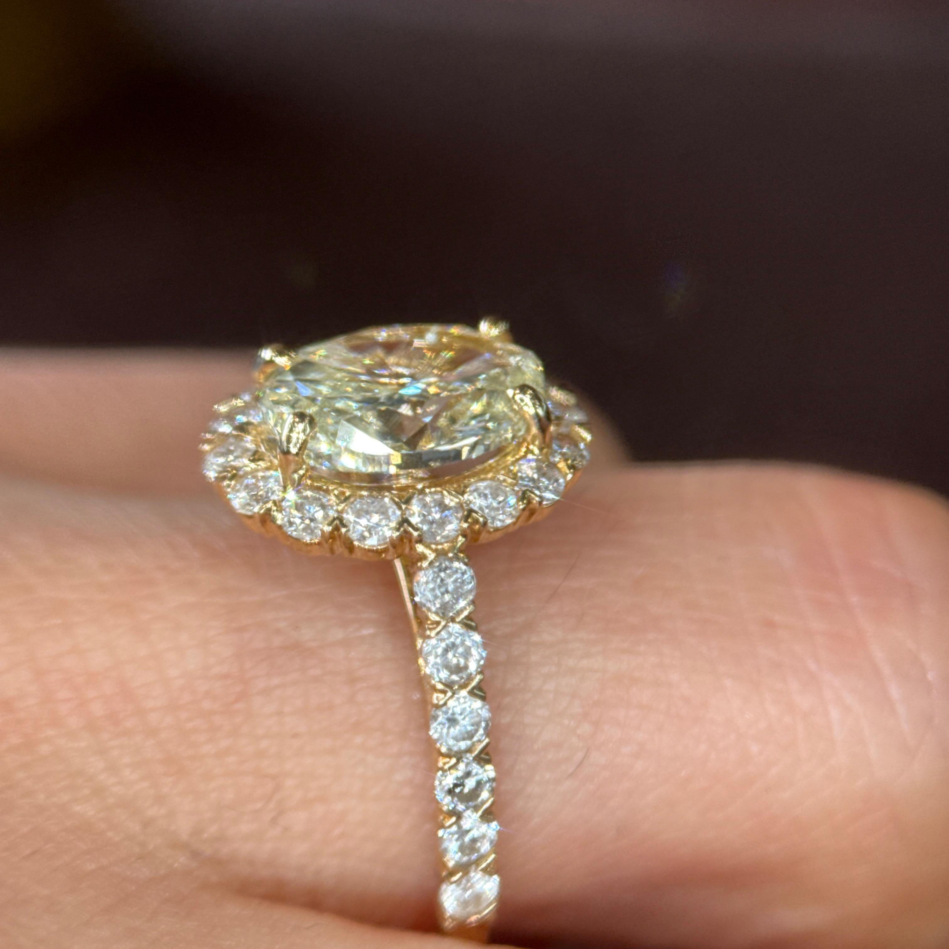 Questo splendido anello di fidanzamento presenta un diamante giallo ovale da 2,50 carati, certificato GIA, incastonato in un lussuoso oro giallo 14 carati. La pietra centrale mostra un colore ricco e una splendida brillantezza, esaltata da