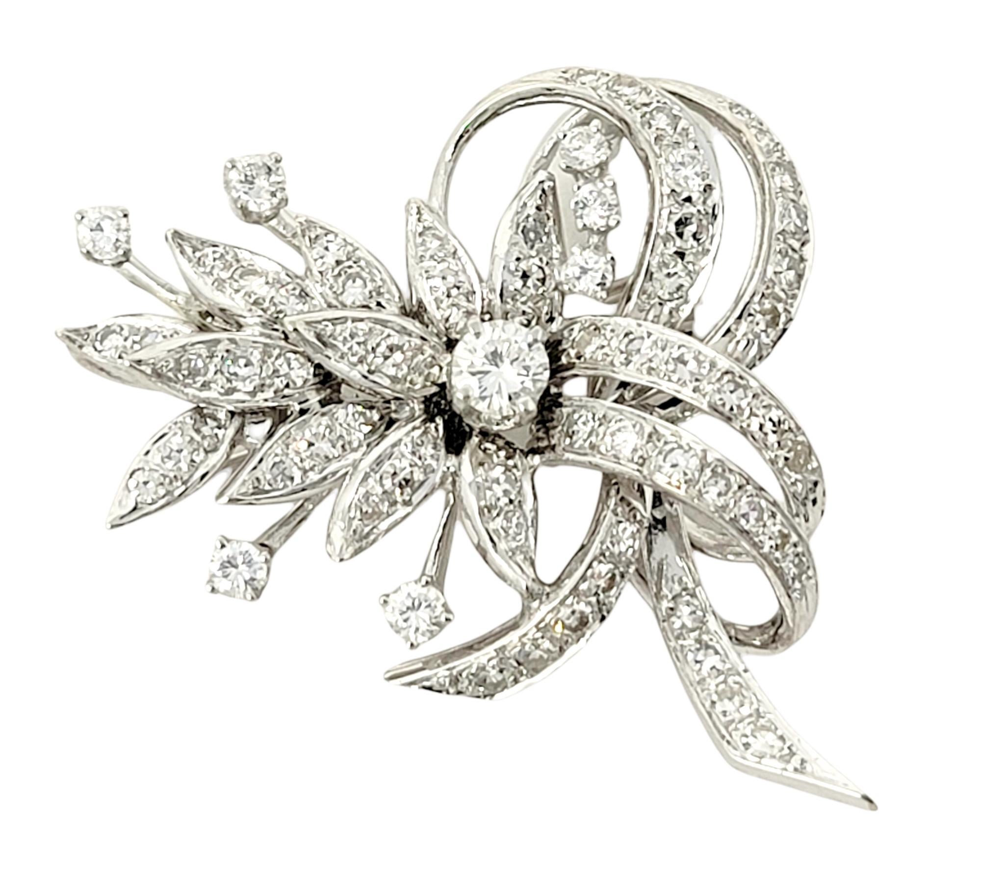 Gorgeous vintage style brooch bursting with incredible sparkle. This absolutely beautiful brooch is made of 14 karat white gold and arranged in a horizontal layout. It features 73 icy white natural round brilliant diamonds set in a clustered floral