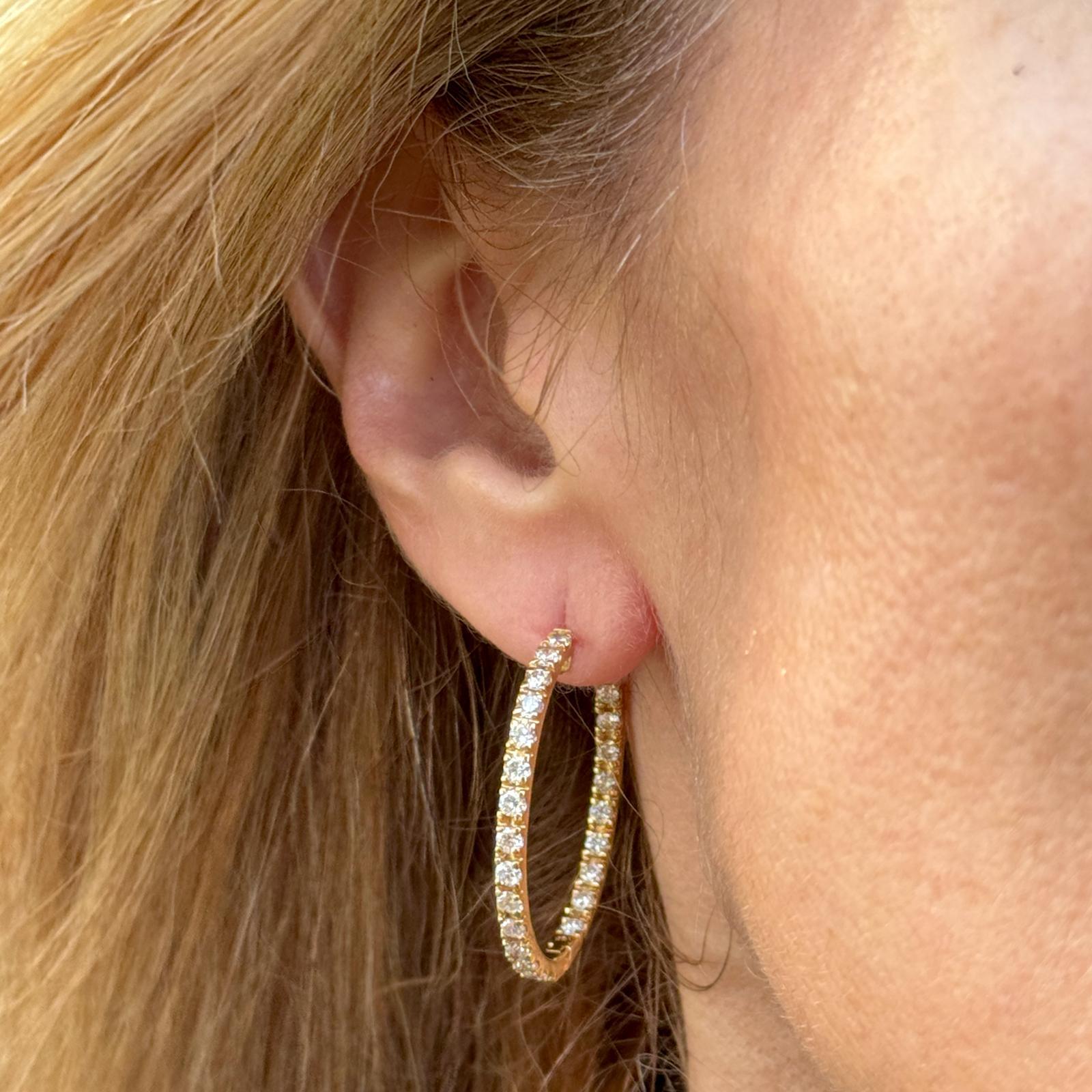 Modern diamond round in and out hoop earrings crafted in 18 karat yellow gold. The earrings feature 52 round brilliant cut diamonds weighing approximately 2.50 carat total weight and graded F-G color and VS2-SI1 clarity. The hoops measure 1.25