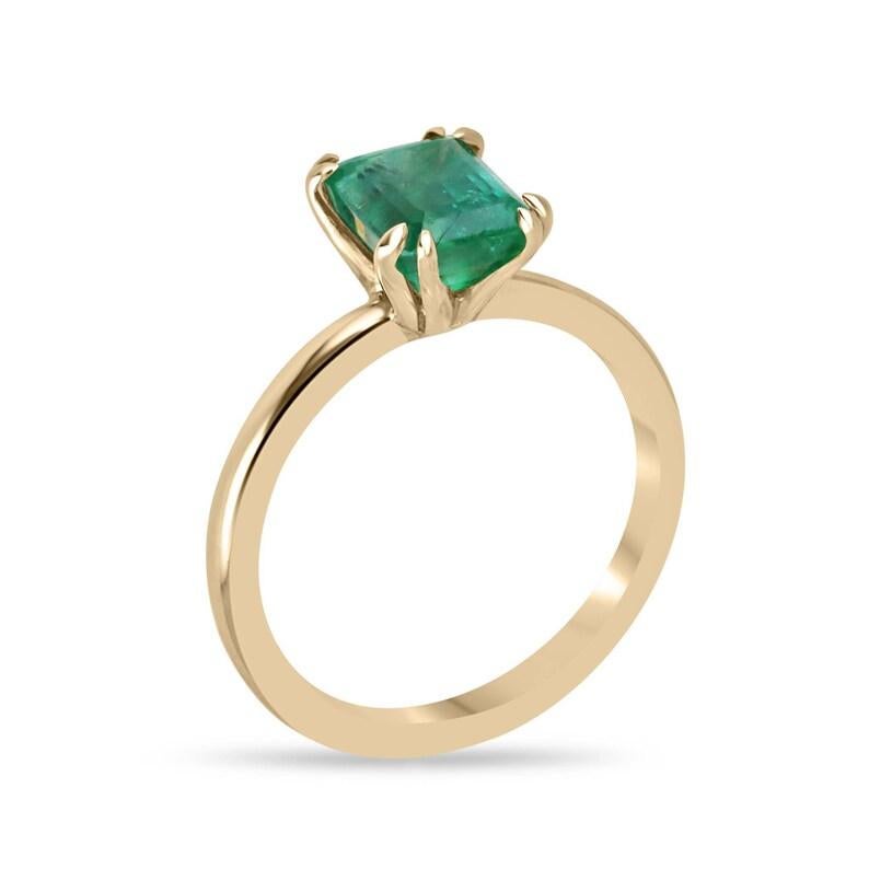 Deléitate con el encanto de nuestro anillo solitario de esmeralda, en el que una magnífica esmeralda talla esmeralda ocupa el centro del escenario, engarzada verticalmente en una montura de cuatro garras dobles elaborada en radiante oro de 14k. Con