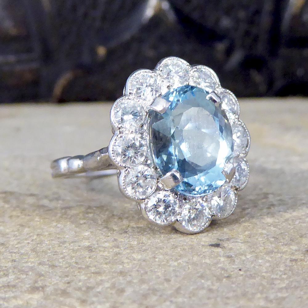 This contemporary Ring has been crafted to resemble an Edwardian style. It has a 2.50ct dazzling Aquamarine in the centre of the ring and surrounded by a halo of 12 Round cut Diamonds. Complimenting the gem stones in a 18ct White Gold rub over