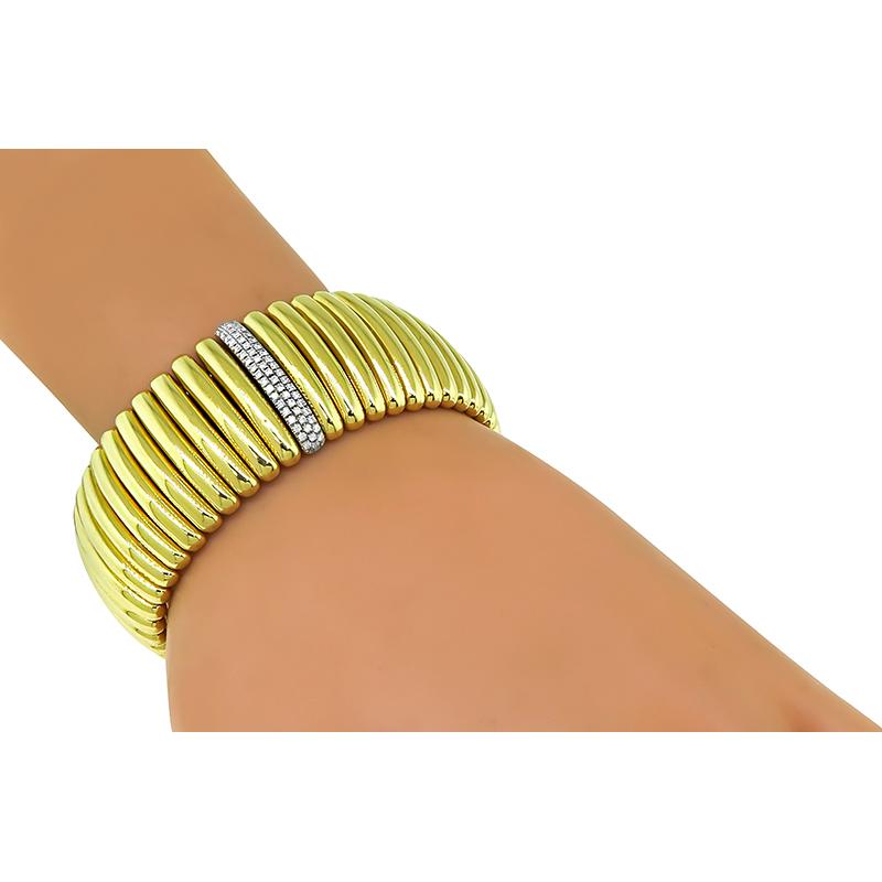 This is an elegant 18k yellow gold flexible ring and bangle set. The set features sparkling round cut diamonds that weigh approximately 2.50ct. The color of these diamonds is F-G with VS clarity. The bangle measures 25mm in width and will fit