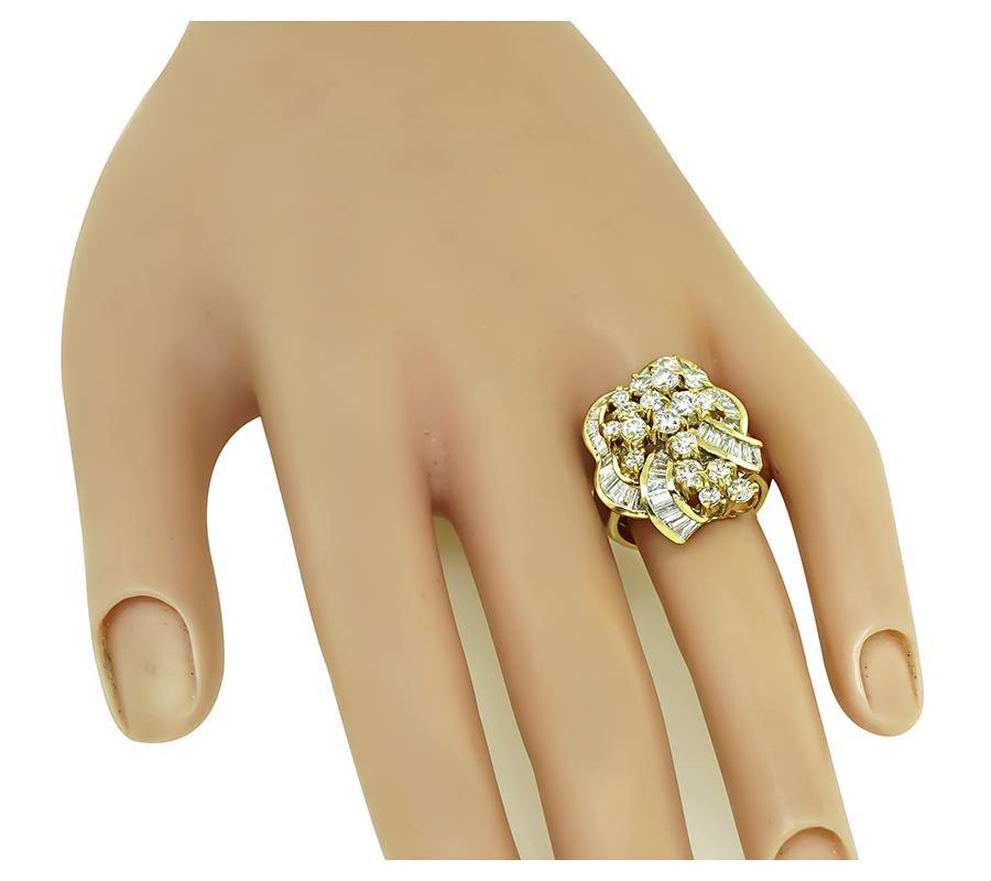 Il s'agit d'une fabuleuse bague en or jaune 18k. La bague est sertie de diamants ronds et baguettes étincelants pesant environ 2.50 ct. La couleur des diamants est H avec une clarté VS. La partie supérieure de l'anneau mesure 24 mm sur 19 mm. La