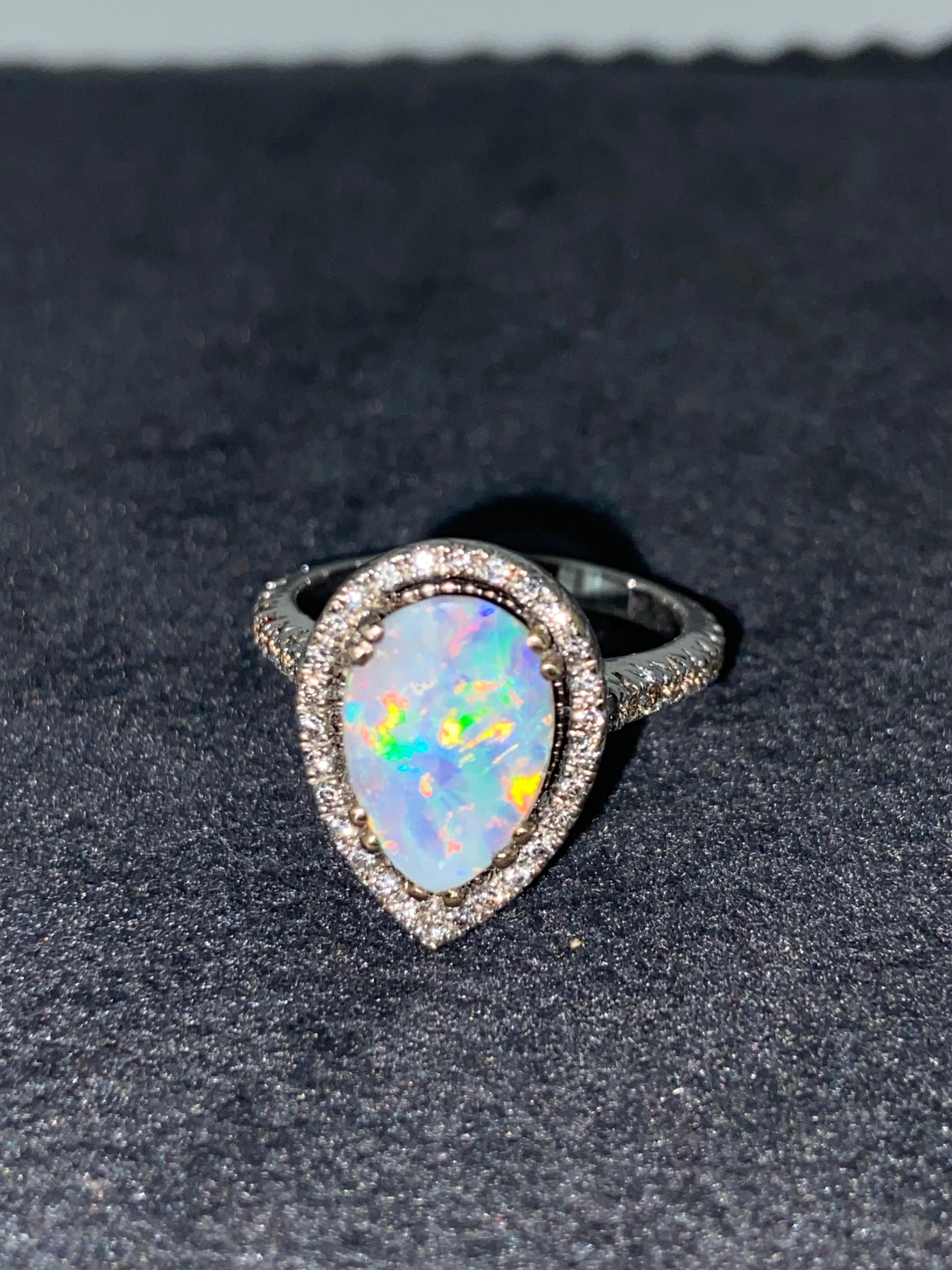 Performed in 18K White Gold, 
the ring is centrally set with 
a magnificent pear-cut 
Australian Boulder Opal 
of impressive 2.50ct 
(12.5mm x 8.5mm approx.), 
from Winton, QLD 
displaying the most unique & stunning 
myriad of colours: 
from