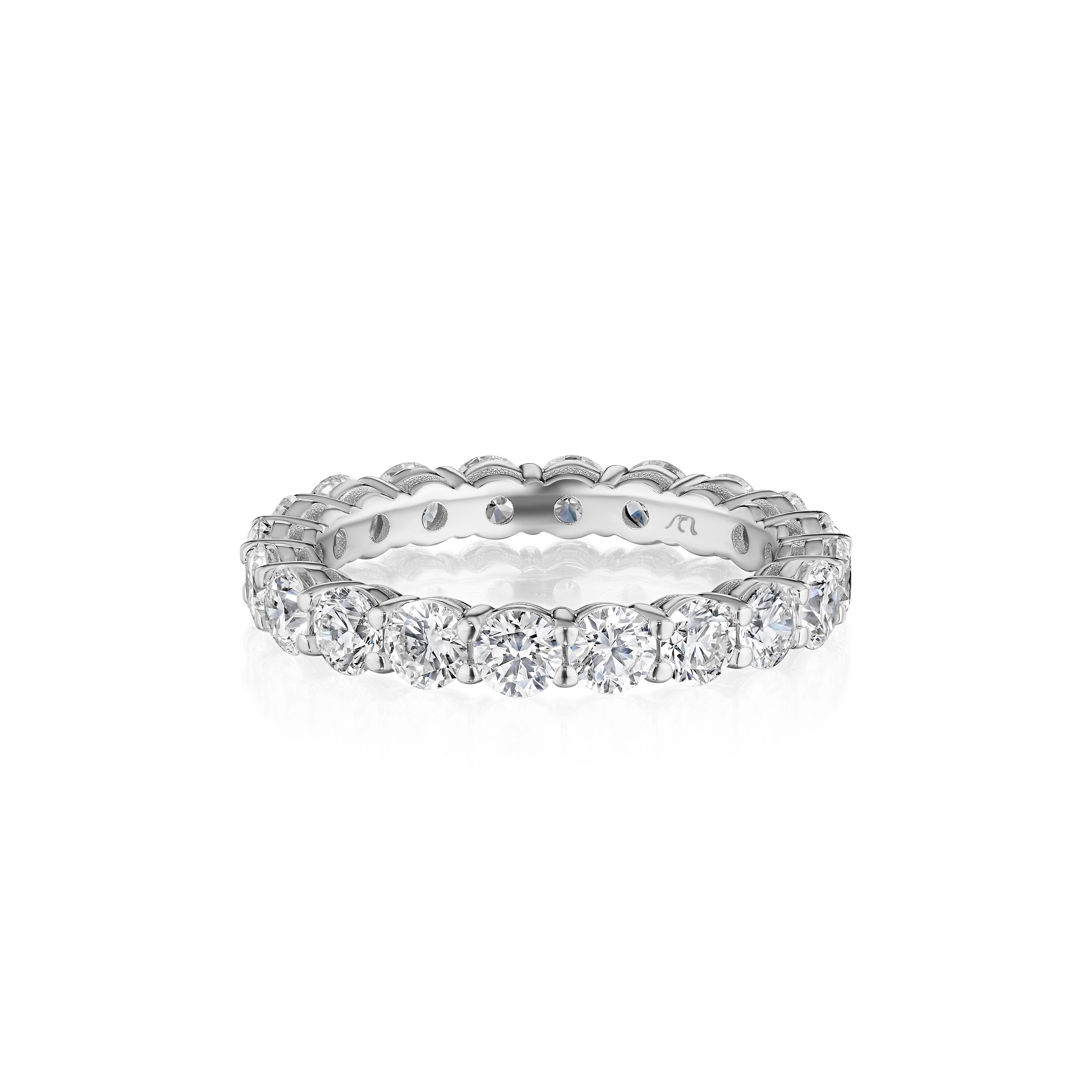• Crafted in 18KT gold, this eternity band is made with 20 round brilliant cut diamonds which encircle the finger, and has a combining total weight of approximately 2.50 carats. The diamonds are set into a shared prong setting. Worn beautifully on