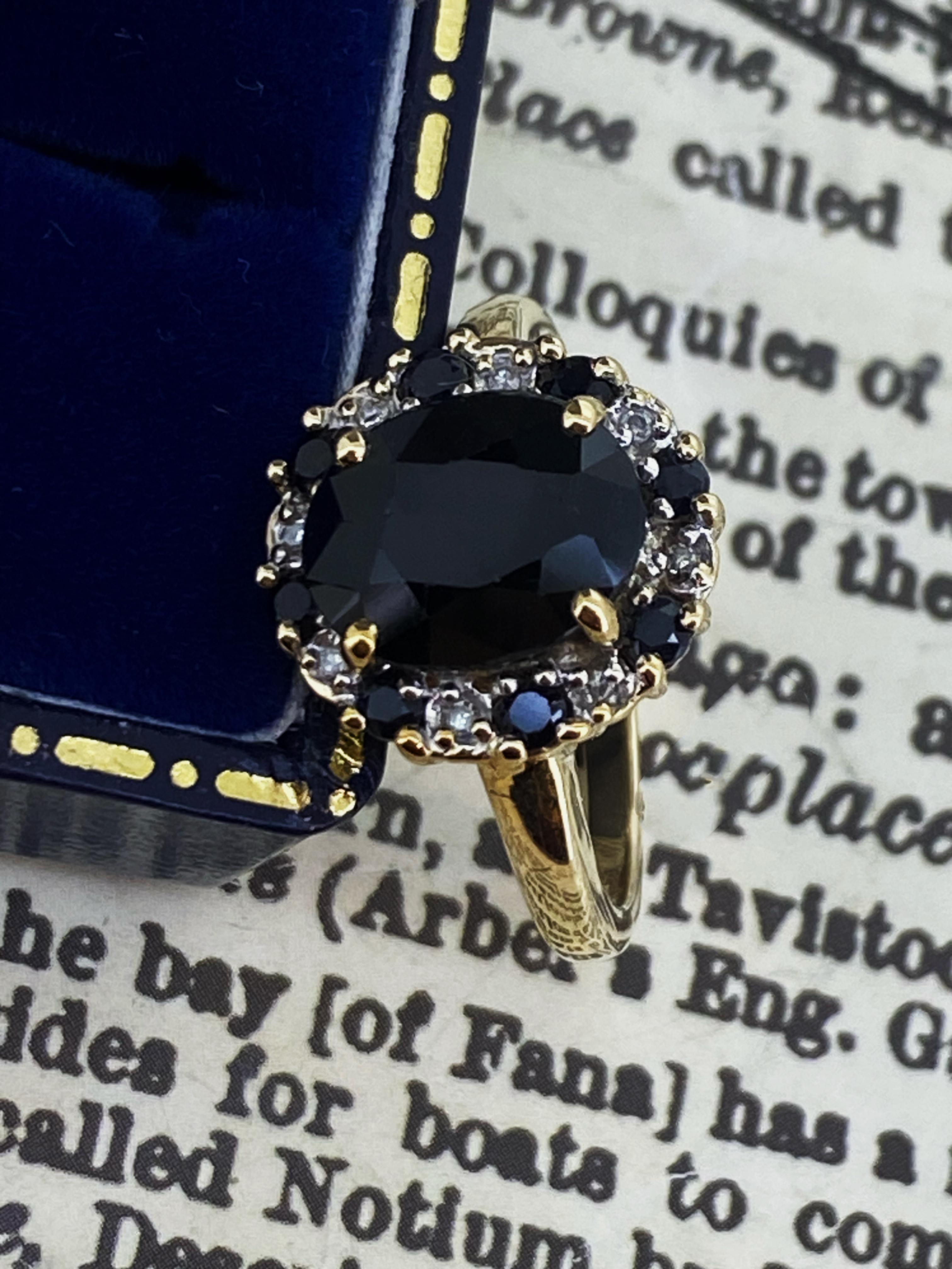 Mit wunderschönem Blumenmotiv, 
dieser Cluster-Ring ist exquisit gearbeitet
aus 9K Gelbgold 
mit einer Ansammlung von Edelsteinen, 
eine Blüte bildend

Set mit 9 natürlichen Saphiren, 
von runden und ovalen Schliffen, 
australischer Herkunft, 
von