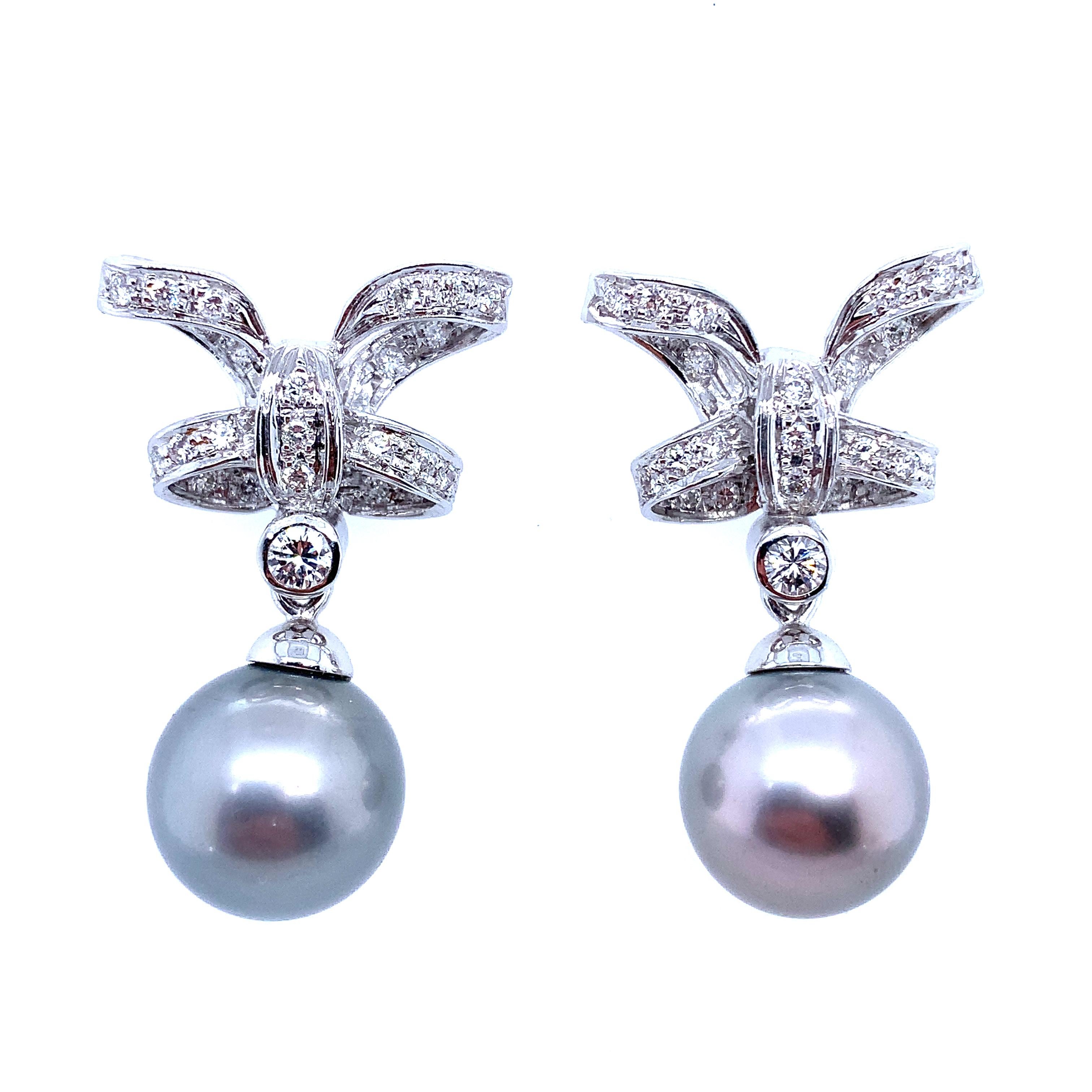 Gorgeous Tahitian platinum grey pearl and diamonds drop earrings in 18k white gold.
Each set with a grey cultured pearl drop measuring approximately 35mm length, upper width of the bow tie approximately 22mm with the depth 8mm suspended from round