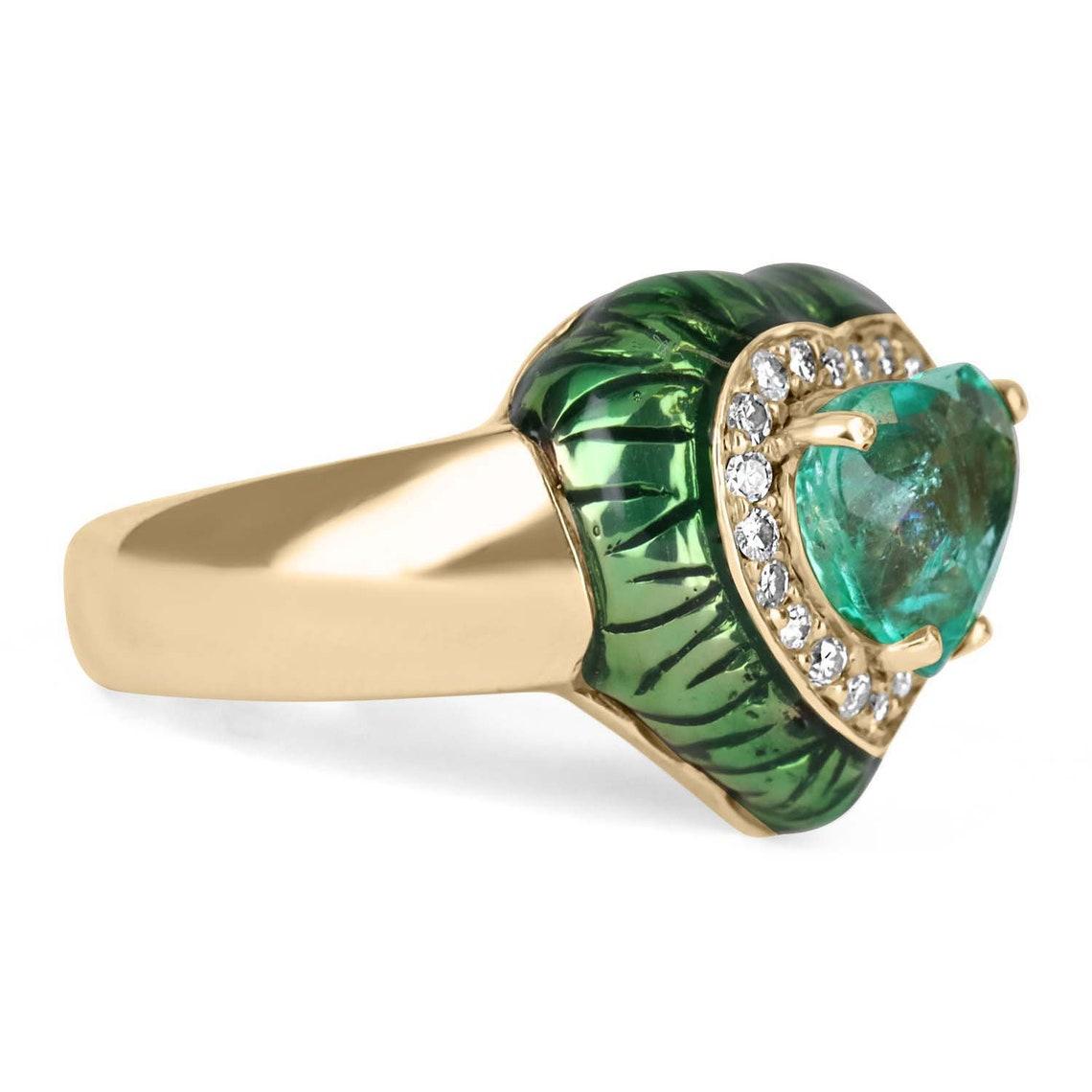 A fine, vivacious, natural Colombian emerald heart & diamond ring. The center gem is a rare cut gemstone possesses numerous enticing qualities, of the which are the following; a vivid bluish-green color is known to only be inhabited by emeralds