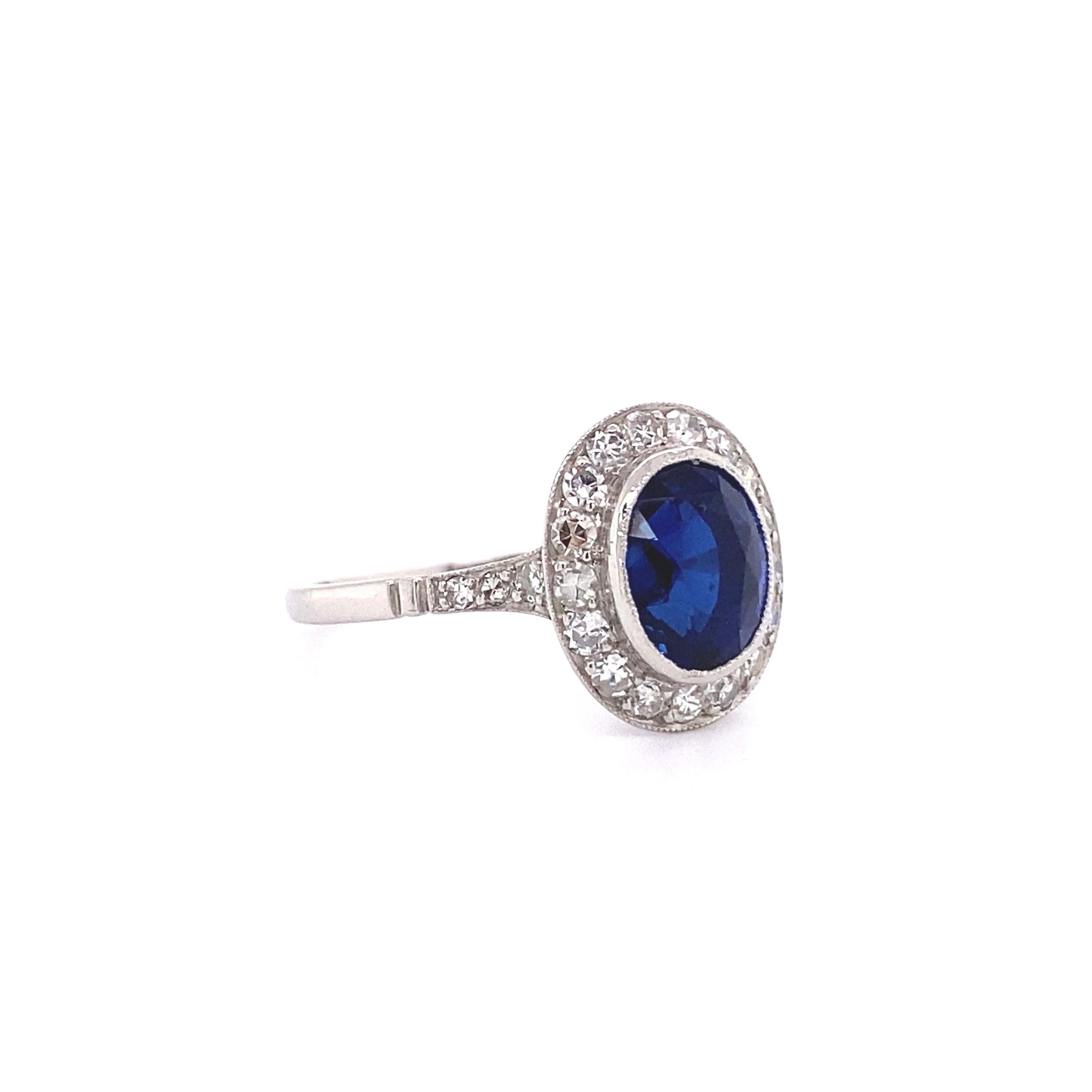 Simply Beautiful! Finely detailed Statement Platinum Show Stopper Ring, center Bezel Hand set with a securely nestled 2.51 Carat oval Blue Sapphire with no indications of heat treatment, surrounded by and enhanced on shank with Hand set pave