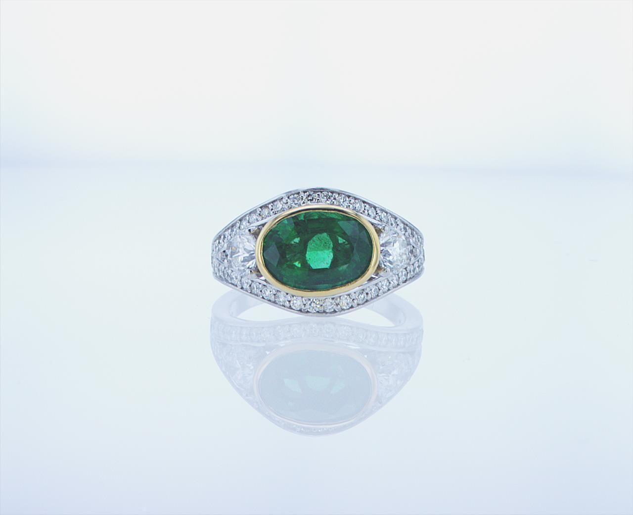2.51ct Oval Emerald Cocktail ring featuring 0.72ct Total Weight of Large Roundnd Side Diamonds and 0.84ct Total Weight of Small Round Side Diamonds (All G/H Color, VS Clarity) in a Platinum Mounting with Yellow Gold Bezel.
