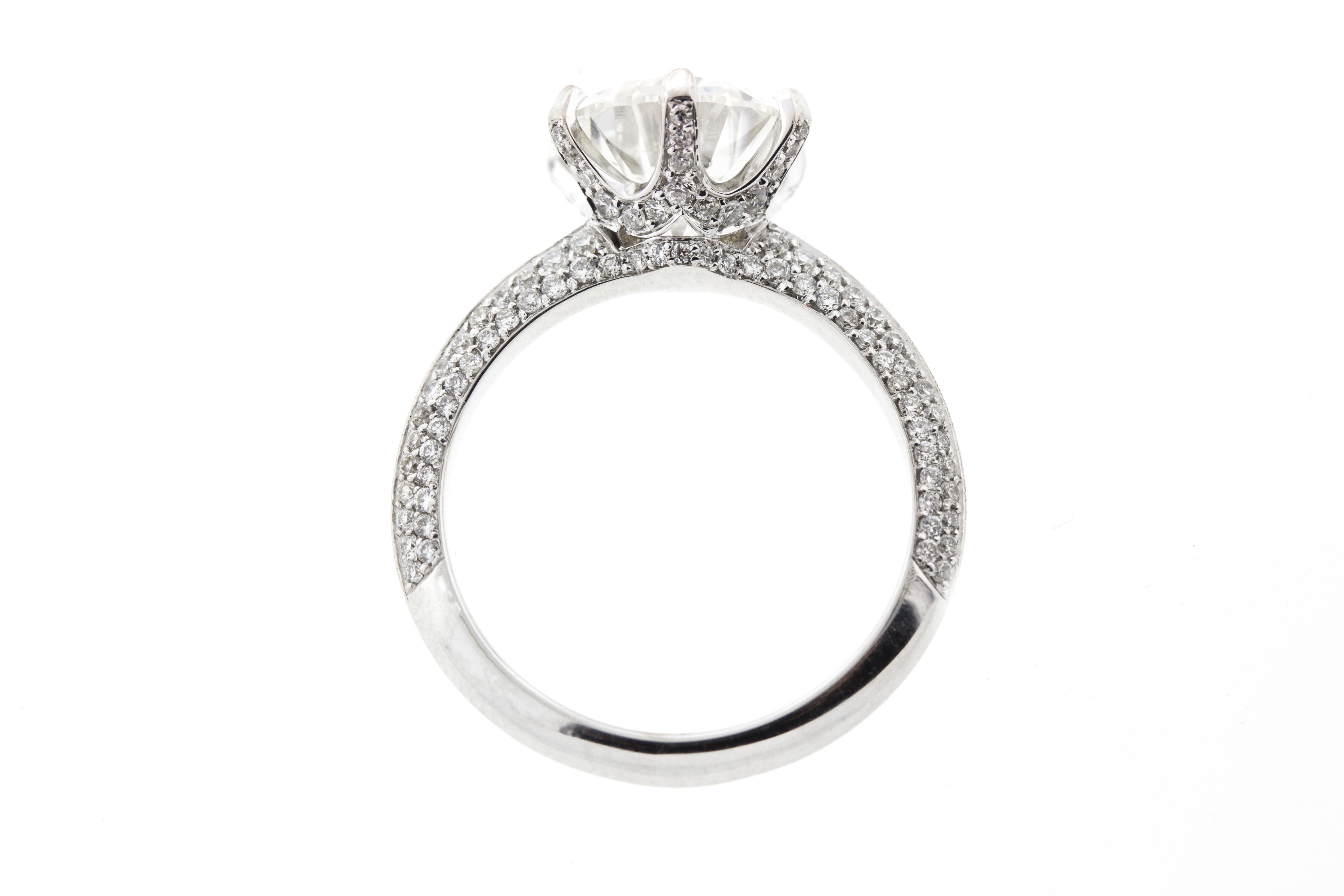 This six prong diamond engagement ring features micropave on three sides of the band, creating a continuous, crushed ice look. A round center stone is cradled by six prongs and boasts its own micropave underneath the basket for a truly unique look.