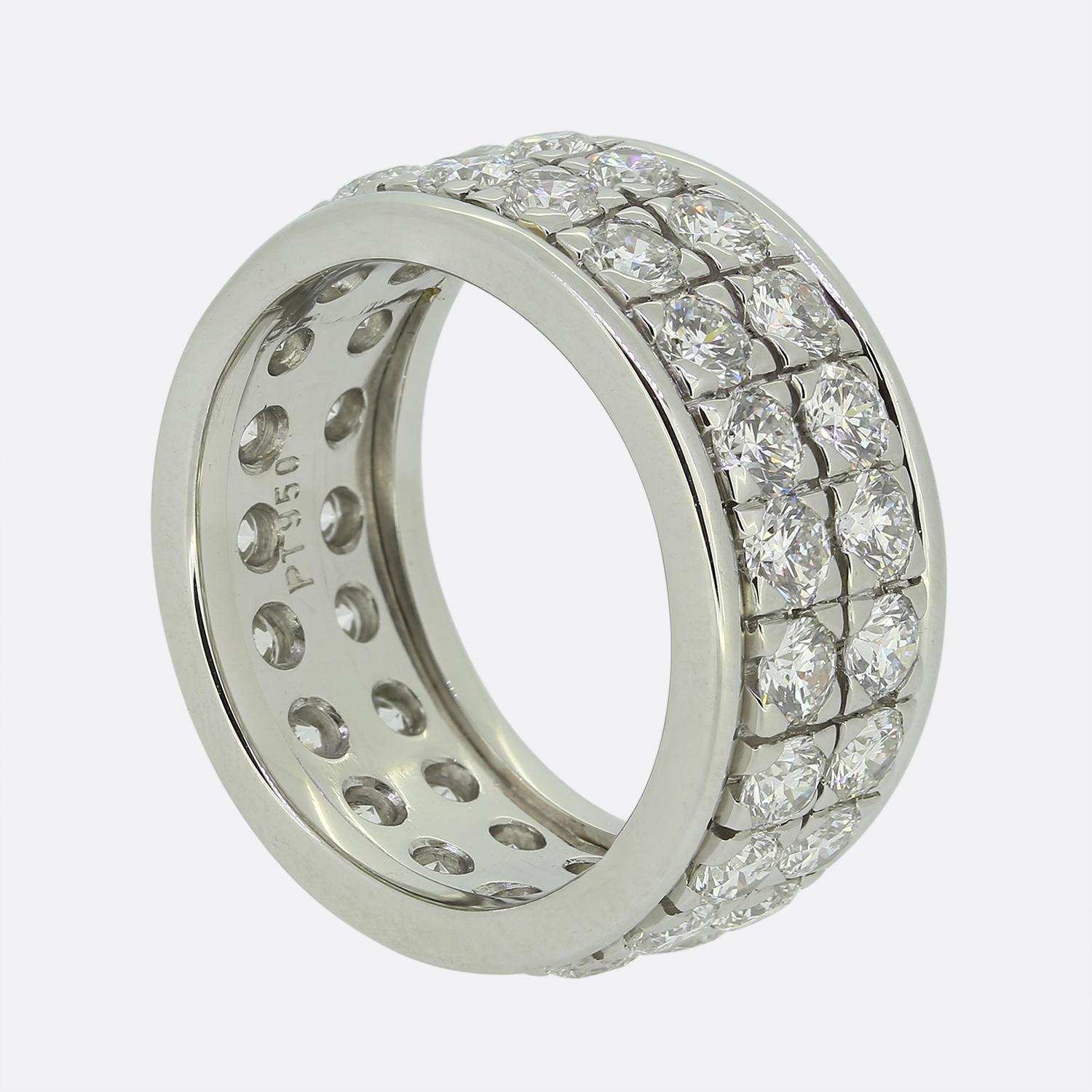 Here we have a marvellous diamond eternity ring. Crafted from platinum, this piece showcases two rows of individually claw set round brilliant cut diamonds amidst a polished channelled setting above and below which wraps around the entire finger.