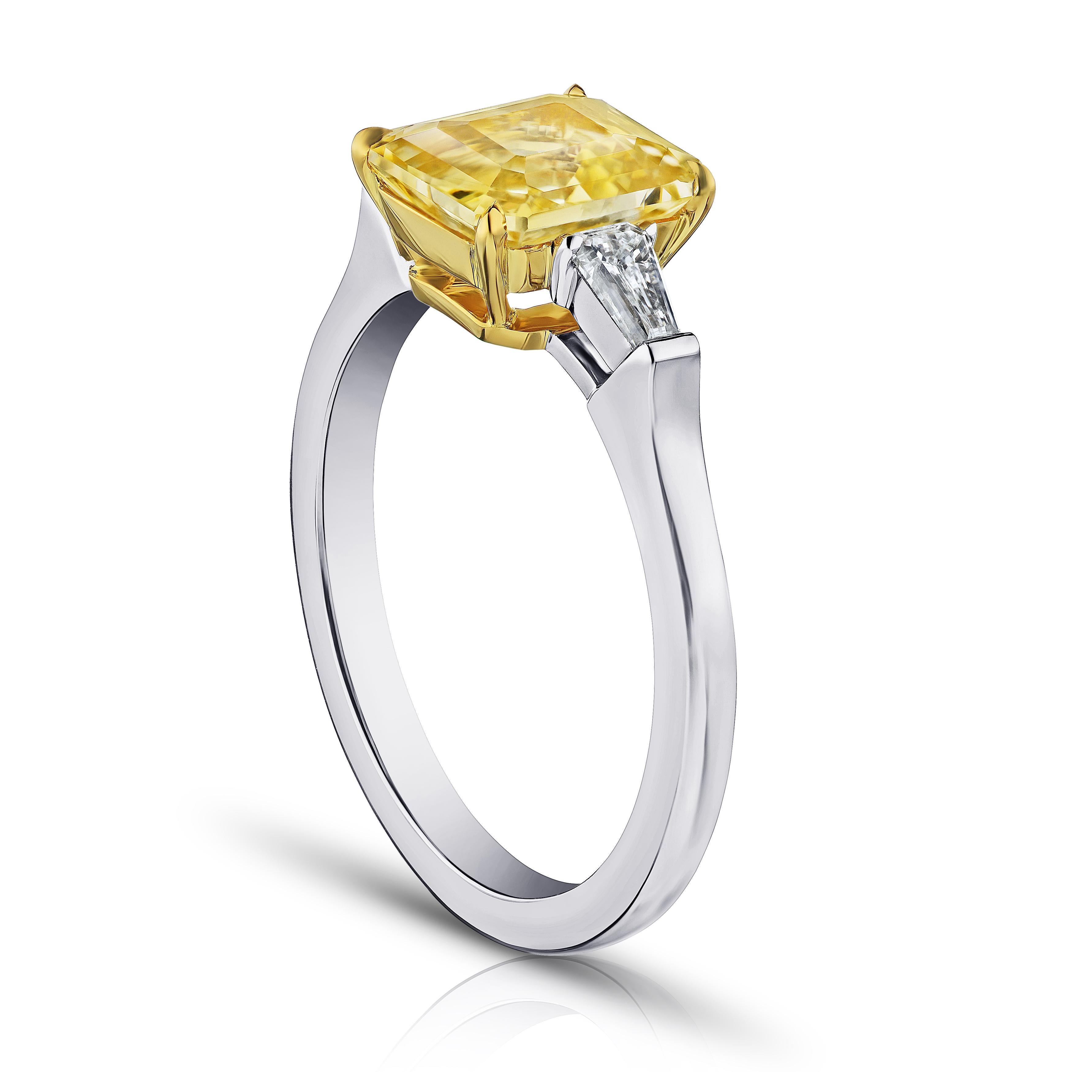 2.52 carat emerald cut yellow sapphire with tapered emerald cut diamonds .27 carats set in a platinum with 18k yellow gold ring. This ring is currently a size 7.  We will resize to your finger size without charge.