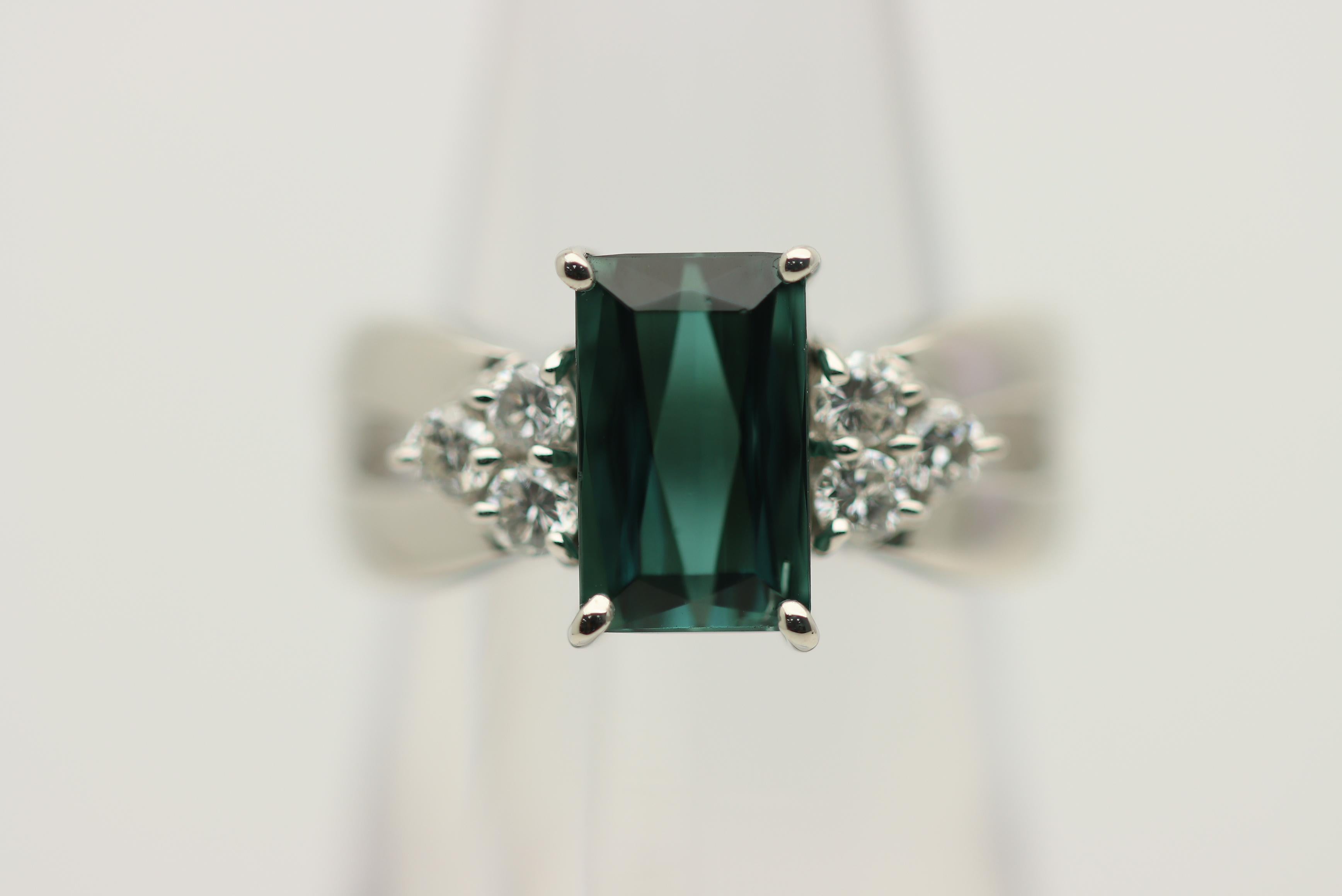 A unique and stylish ring featuring a gem indicolite tourmaline. It weighs 2.52 carats and has the most pleasing green-blue color that is crystal clear and appears to vibrate in the light. It is complemented by 0.35 carats of diamonds set on its