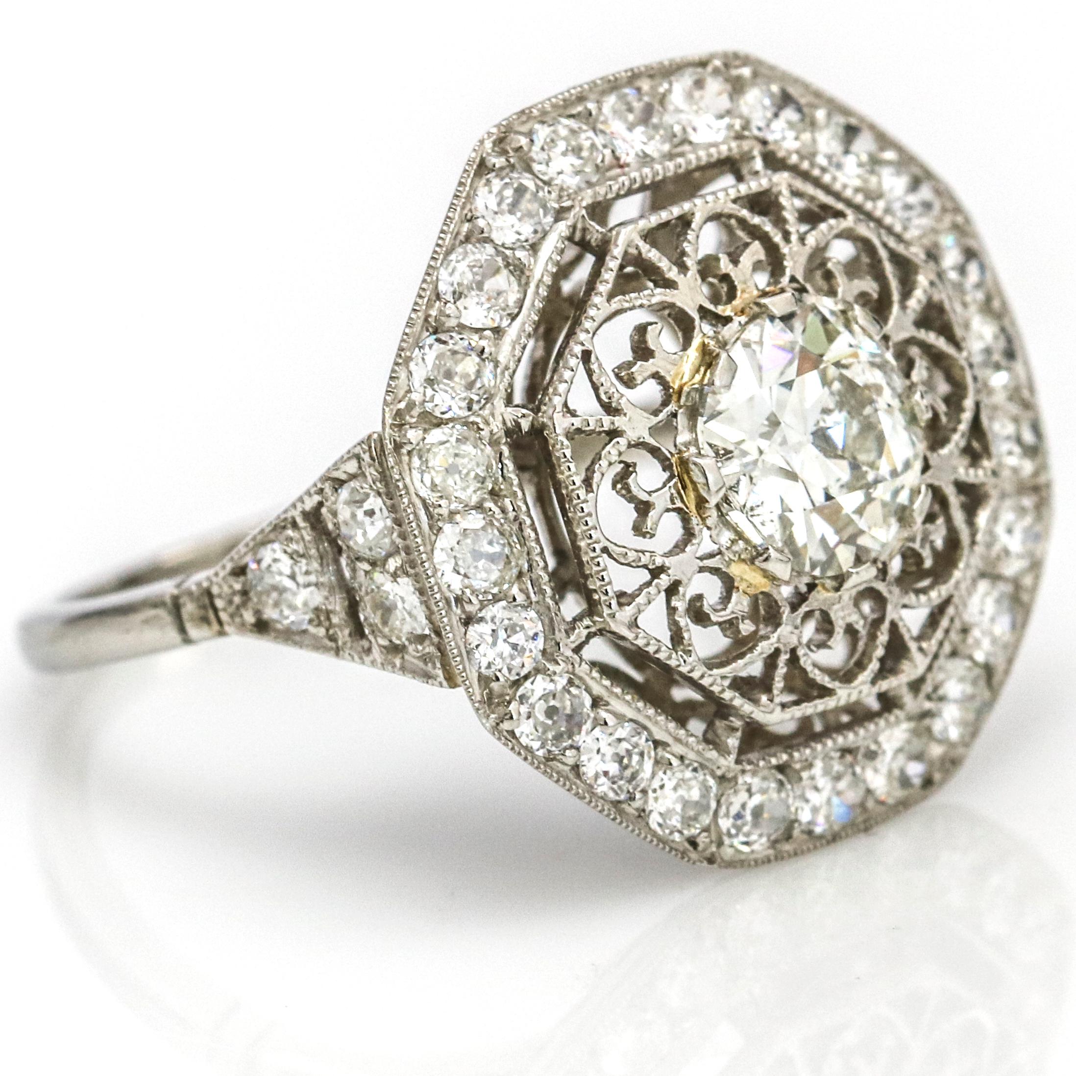 Art Deco diamond engagement ring in platinum. Octagon shaped setting with an old mine cut diamond center that weighs 1.02 carats. There are 30 smaller diamonds on the halo, the estimated carat weight of those diamonds is 1.50 carats. Circa 1920s.