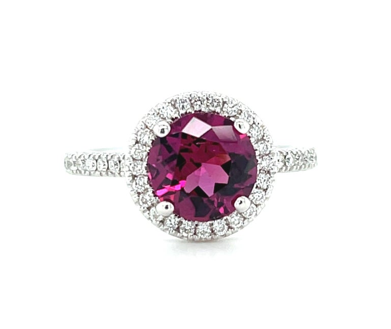 This elegant and classically designed cocktail ring features a bright rhodolite garnet surrounded by a halo of brilliant white diamonds! Named after the Greek word for 
