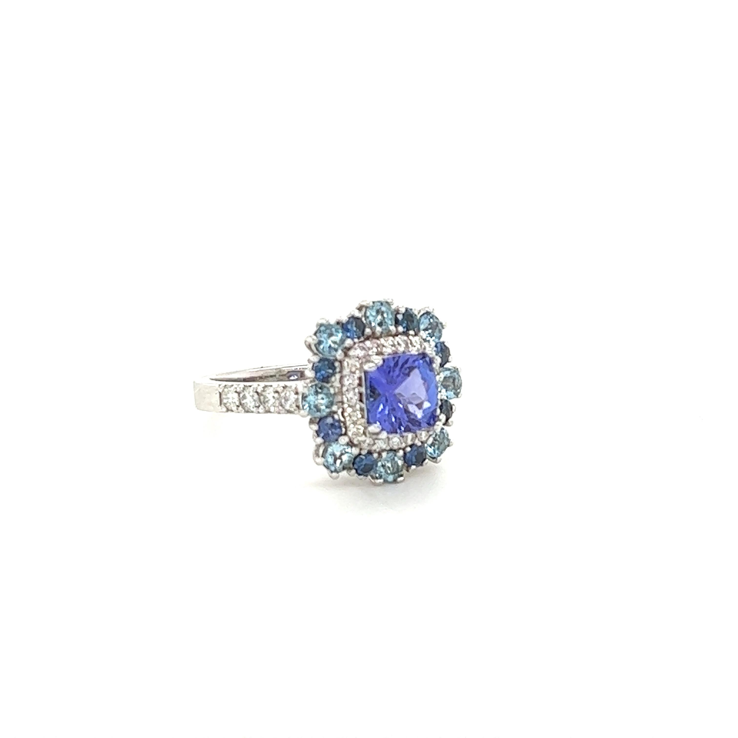This beauty has a 1.15 Carat Natural Cushion Cut Tanzanite as its center and is surrounded by 8 Natural Round Cut Aquamarines that weigh 0.52 carats and 8 Natural Round Cut Blue Sapphires that weigh 0.31 carats. It also has 27 Natural Round Cut