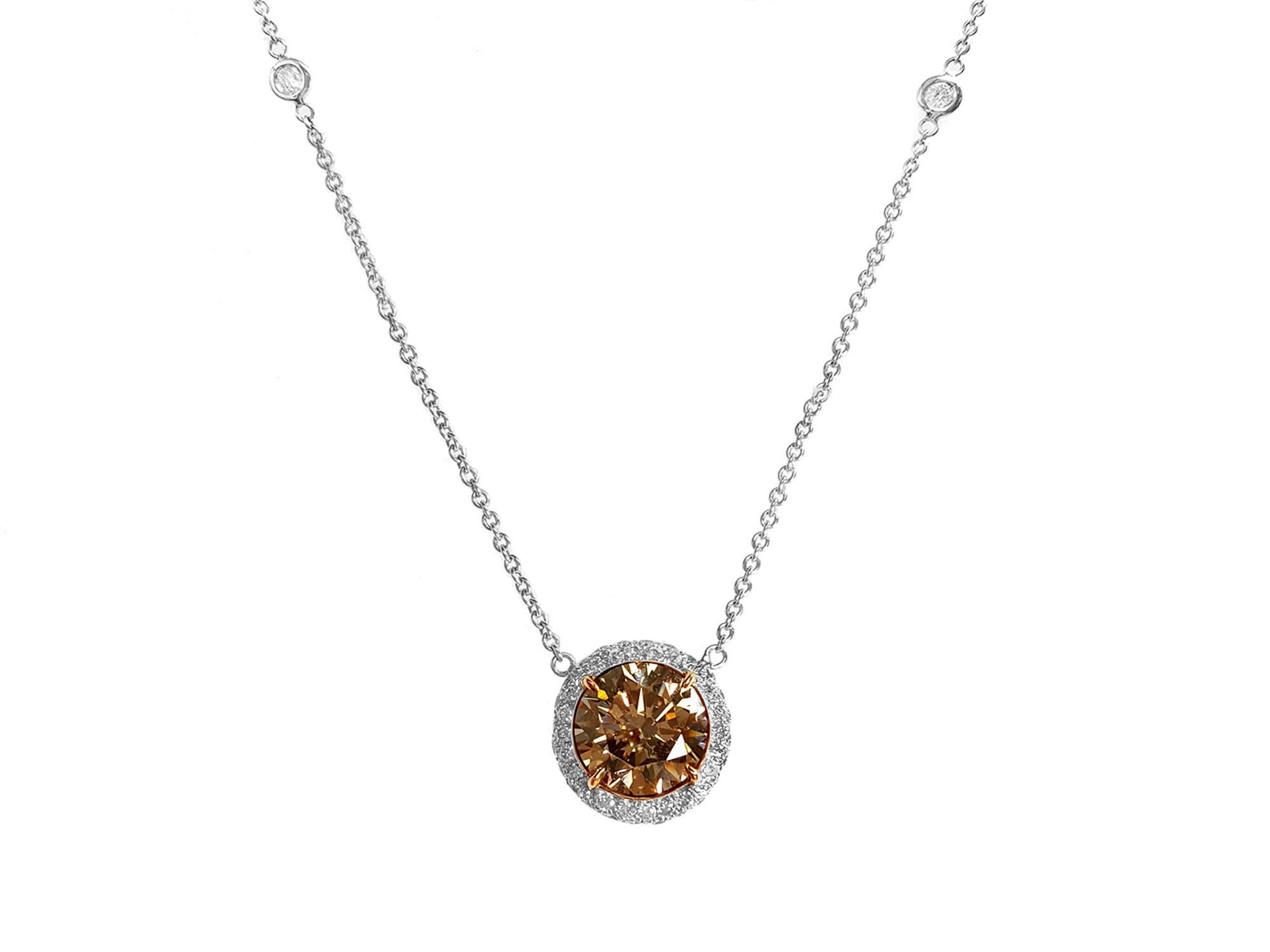 Featuring a stunning Halo Pendant Necklace style showcasing a 2.53 Carat Round Brilliant Brown Diamond in the center. The classic design brings out the beauty of the center stone with the surrounding 39 round cut diamonds, set in a polished 18k