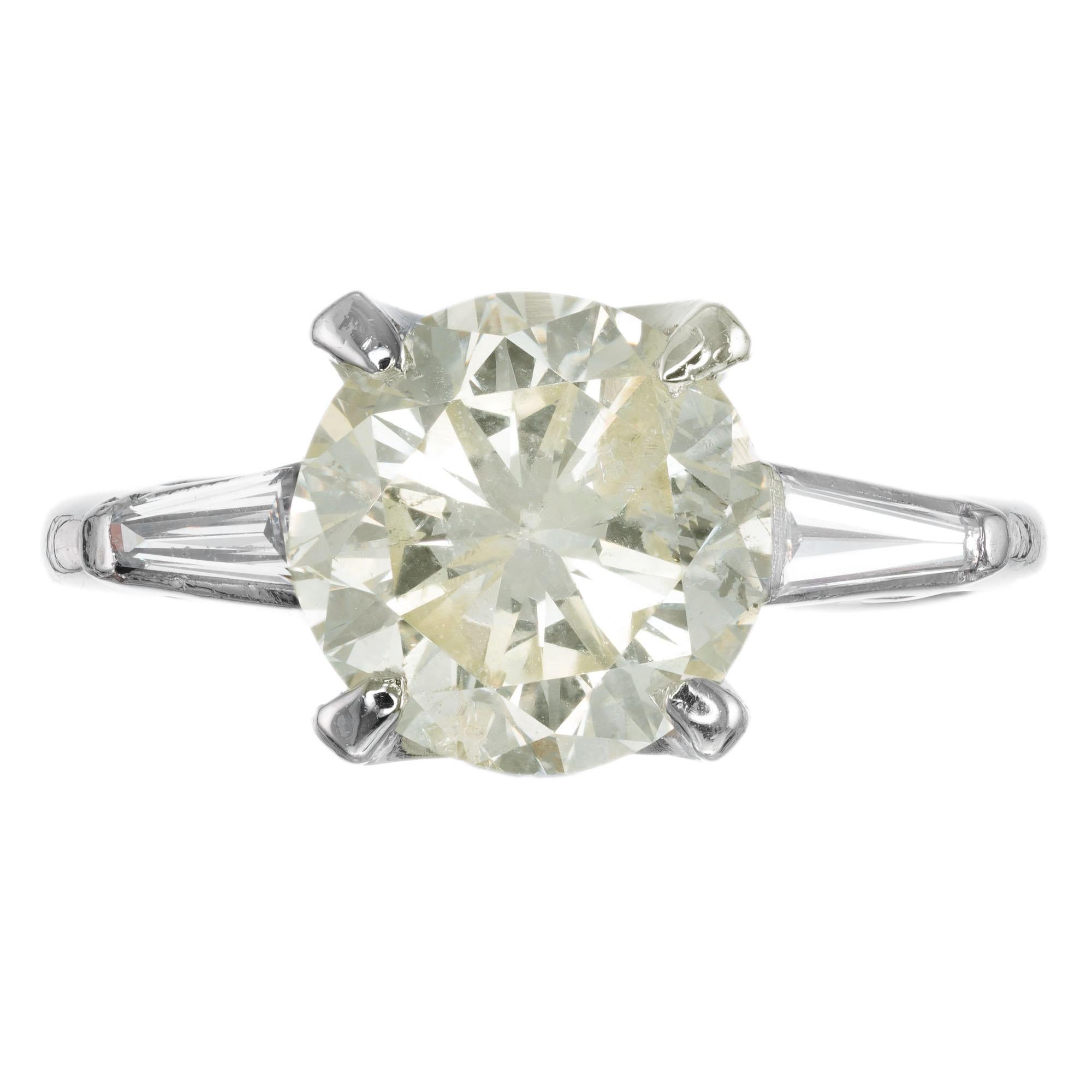 1940s round brilliant cut light yellow center diamond. EGL certified, in a platinum three-stone setting with two baguette side diamonds. 

1 round diamond approx. total weight 2.53cts I1- N 8.60 x 8.44 x 5.41mm  63.6% and the table is 65%  EGL