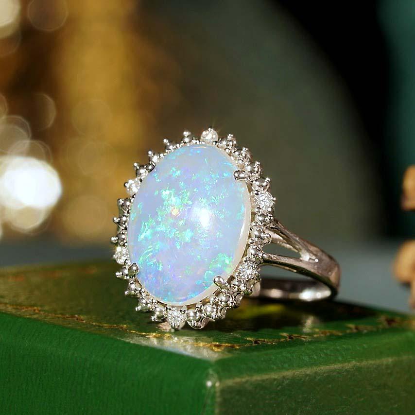 This beautiful ring is a vintage inspired style, the halo ring features play-of-color oval 2.53 carat opal for its center, surrounded by six white diamonds. This would make a wonderful statement ring, or just because it is beautiful. 

Ring