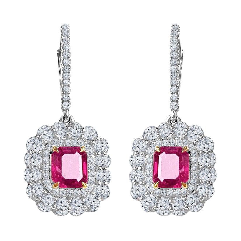 Indulge in the epitome of luxury with our exquisite Fine Ruby Halo Lever Back Hoop Earrings. These captivating earrings showcase the allure of 2.54 carats of emerald cut fine rubies, elegantly set within delicate halos of round white diamonds that