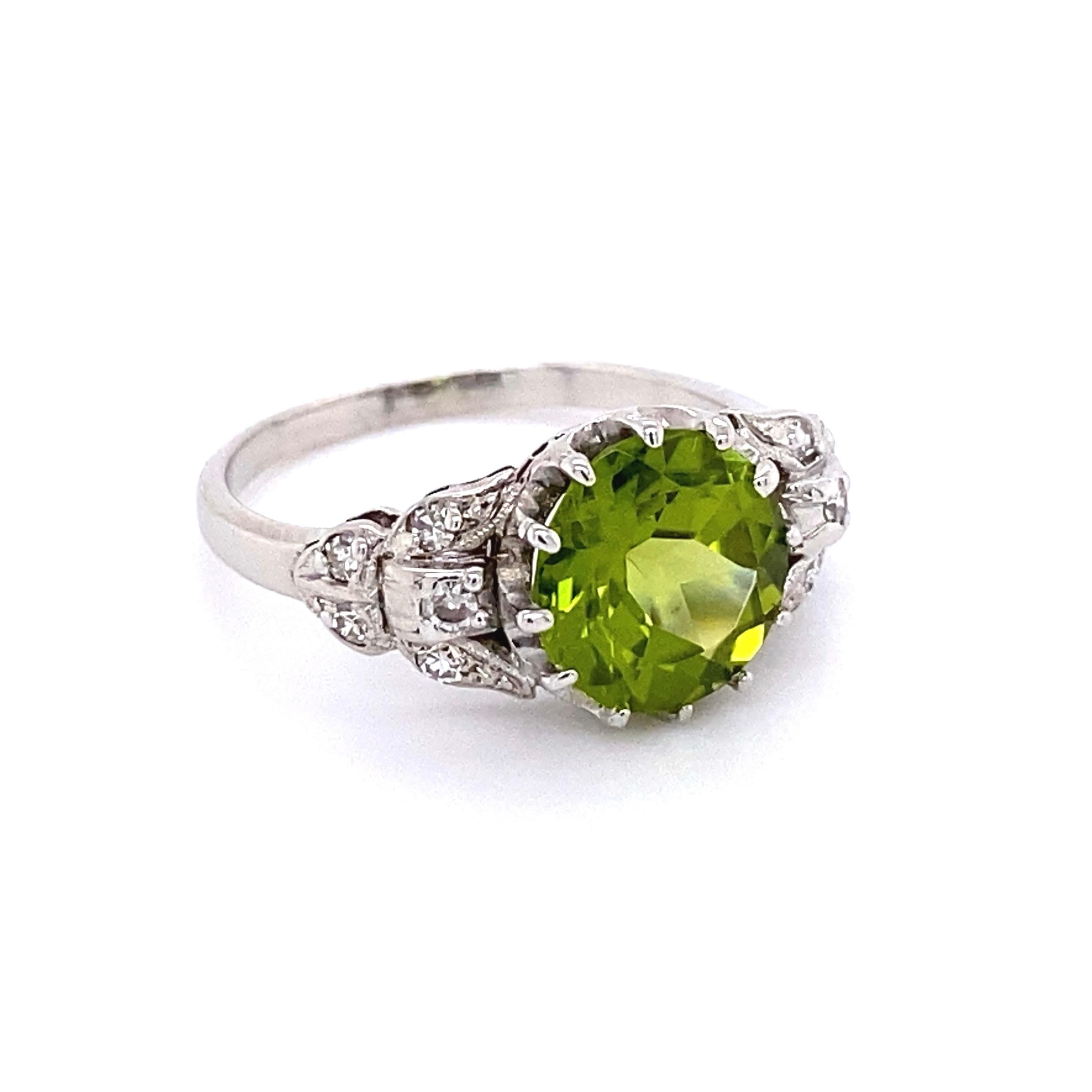 Simply Beautiful! Peridot and Diamond Art Deco Revival Ring. Center securely set with a Peridot, weighing approx. 2.54 Carat, accented by Diamonds on either side, weighing approx.0.10tcw. Finely detailed Hand crafted Platinum mounting. Ring measures