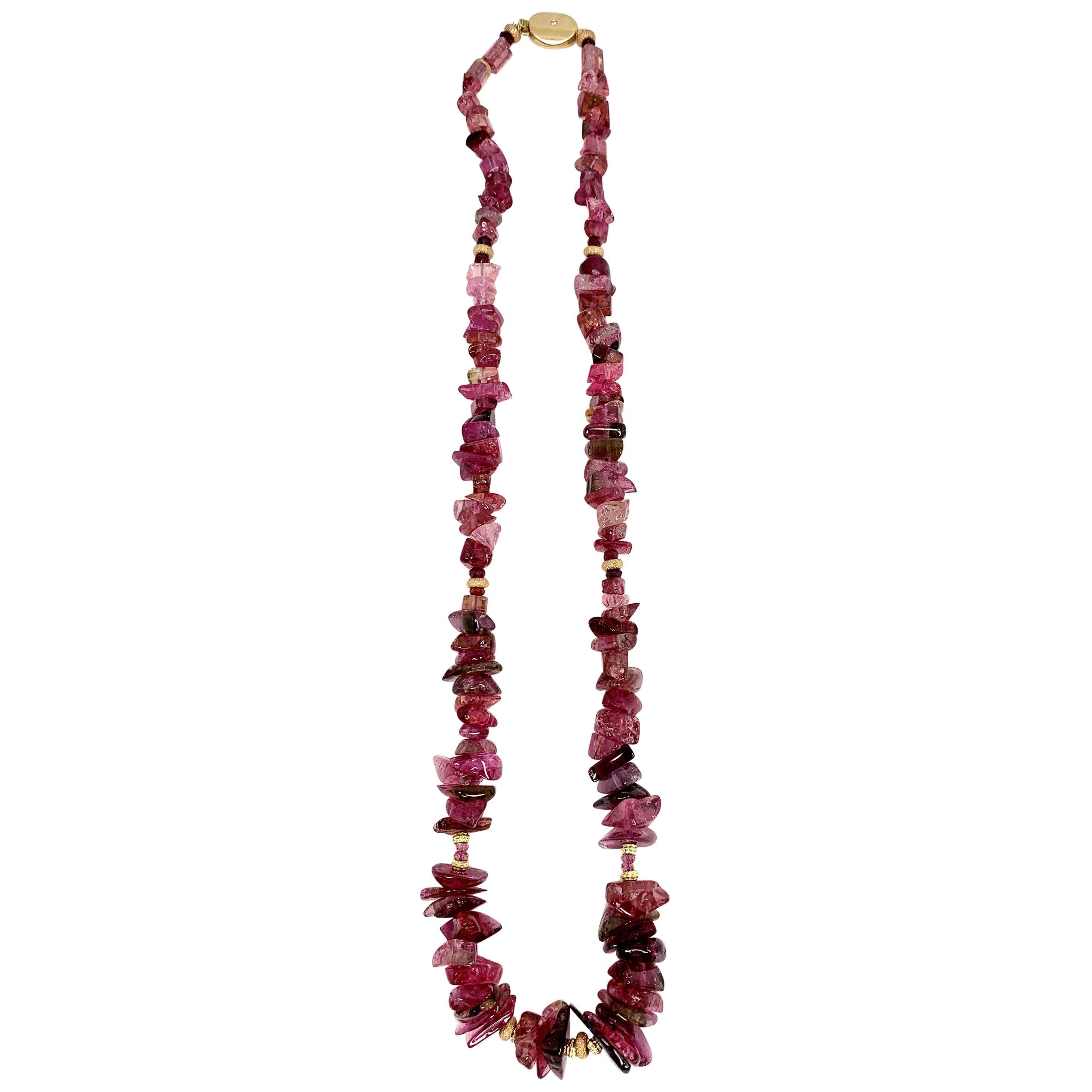 Rough but refined, and bursting with color! This unique necklace features striking shades of raspberry pink tourmalines that weigh over 254 carats total! The gorgeous nugget style beads, each unique in itself, are counterbalanced by shiny 14k and