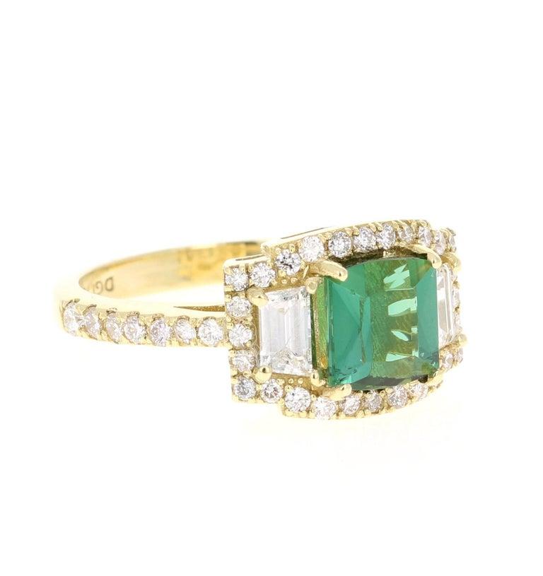 A beauty that is sure to be nothing less than a statement! 

This ring has a magnificently beautiful Emerald-Square Cut Green Tourmaline that weighs 1.60 Carats and has 2 Baguette Cut Diamonds weighing 0.42 Carats. It is further embellished with 42
