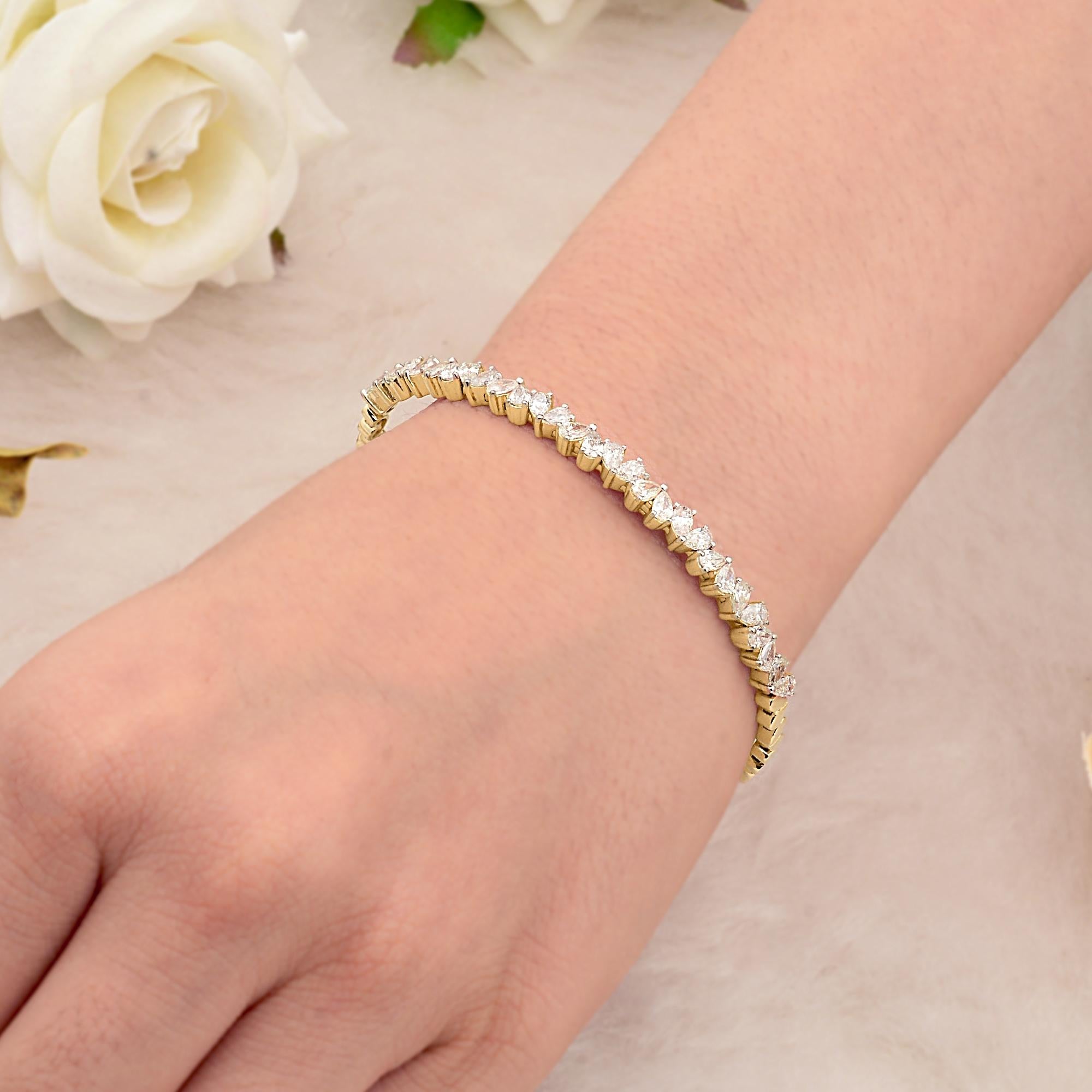 Questo bracciale da polso in oro giallo 14 carati con diamanti a taglio pera SI Clarity HI Color è caratterizzato da diamanti a taglio pera incastonati in fila nella direzione opposta, formando un bracciale aperto. 
I diamanti sono un simbolo