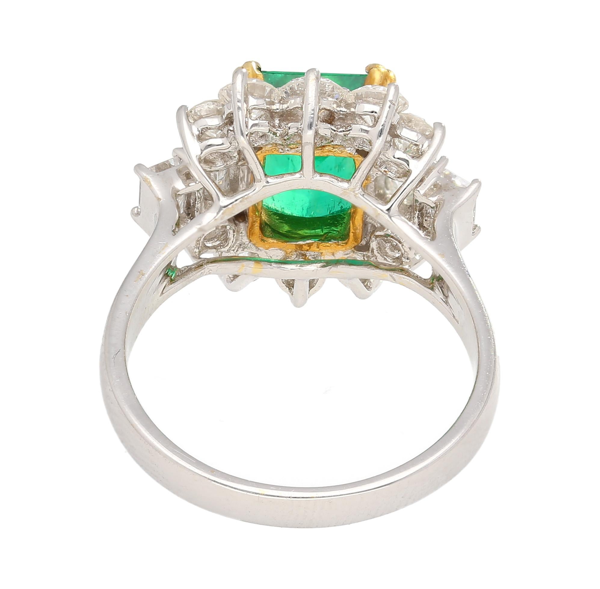 A magnificent natural emerald and diamond ring in 18k white and yellow gold. Set with a 2.55 carat Colombian emerald center stone. Complemented by 4 emerald-cut diamond side stones beside 10 round brilliant-cut diamonds. All of which are F-G color