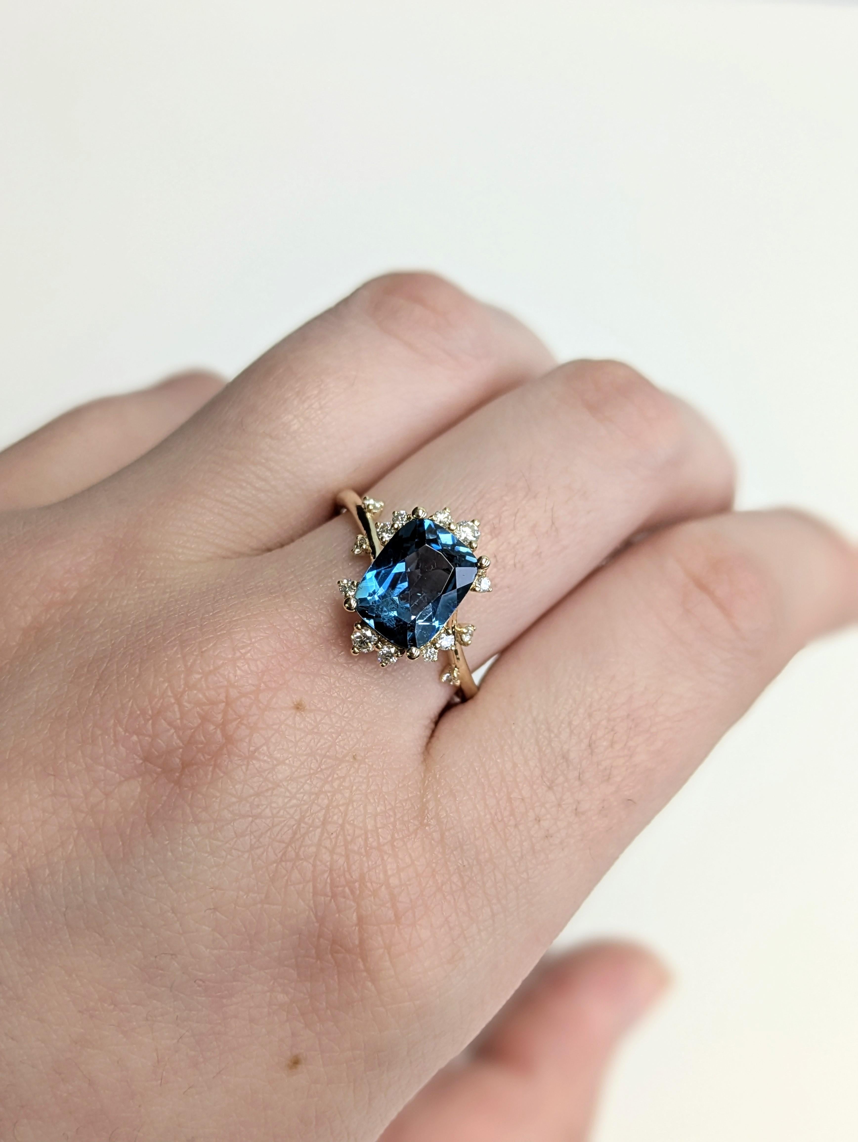 Atrae todas las miradas con este impresionante anillo de topacio azul de Londres de 2,55 quilates, engastado con una llamativa inclinación para una elegancia moderna. Rodeada de brillantes diamantes extraídos de la tierra y elaborada en oro amarillo