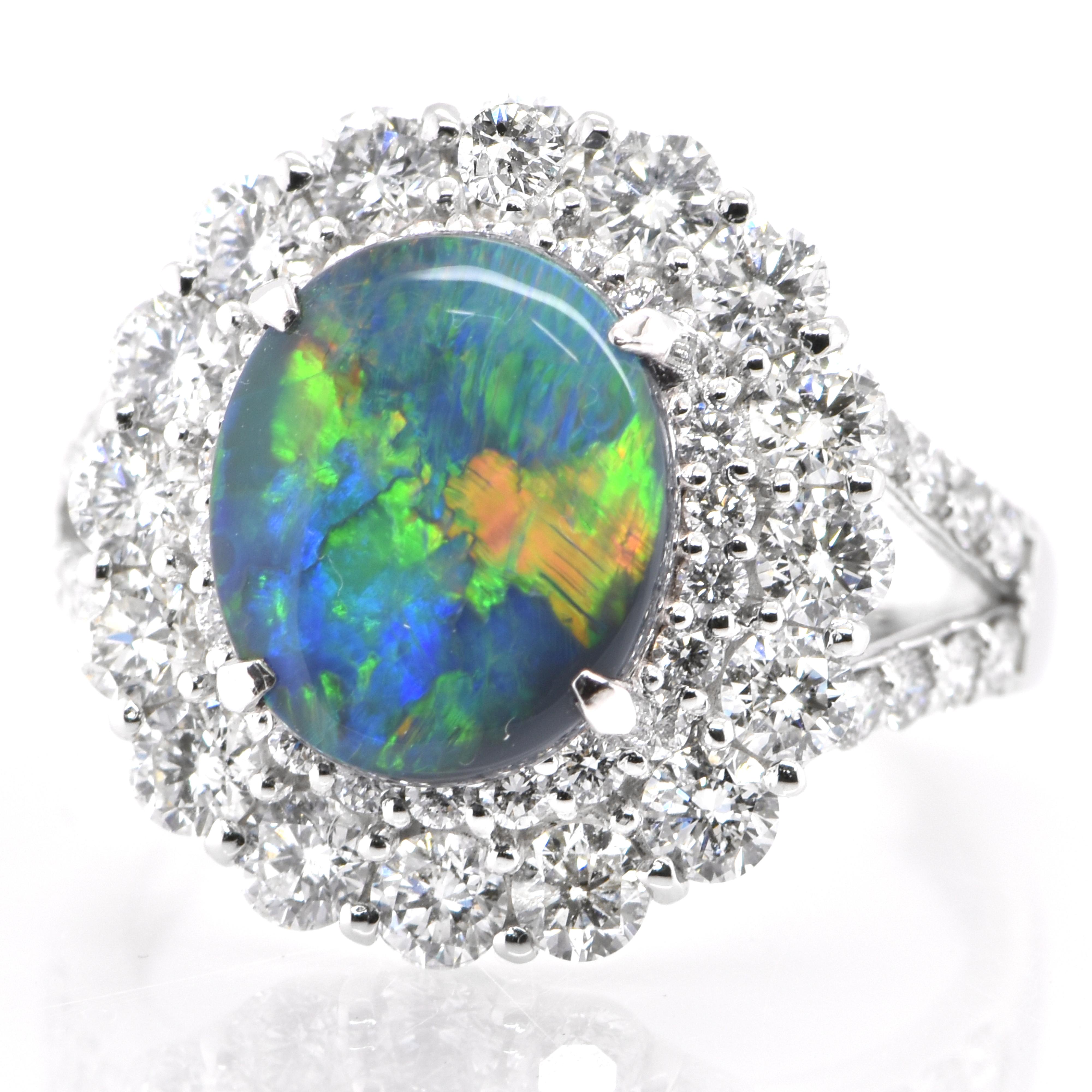 A beautiful halo ring featuring a 2.56 Carat, Natural, Australian Black Opal and 1.68 Carats of Diamond Accents set in Platinum. The Opal displays very good play of color! Opals are known for exhibiting flashes of rainbow colors known as 