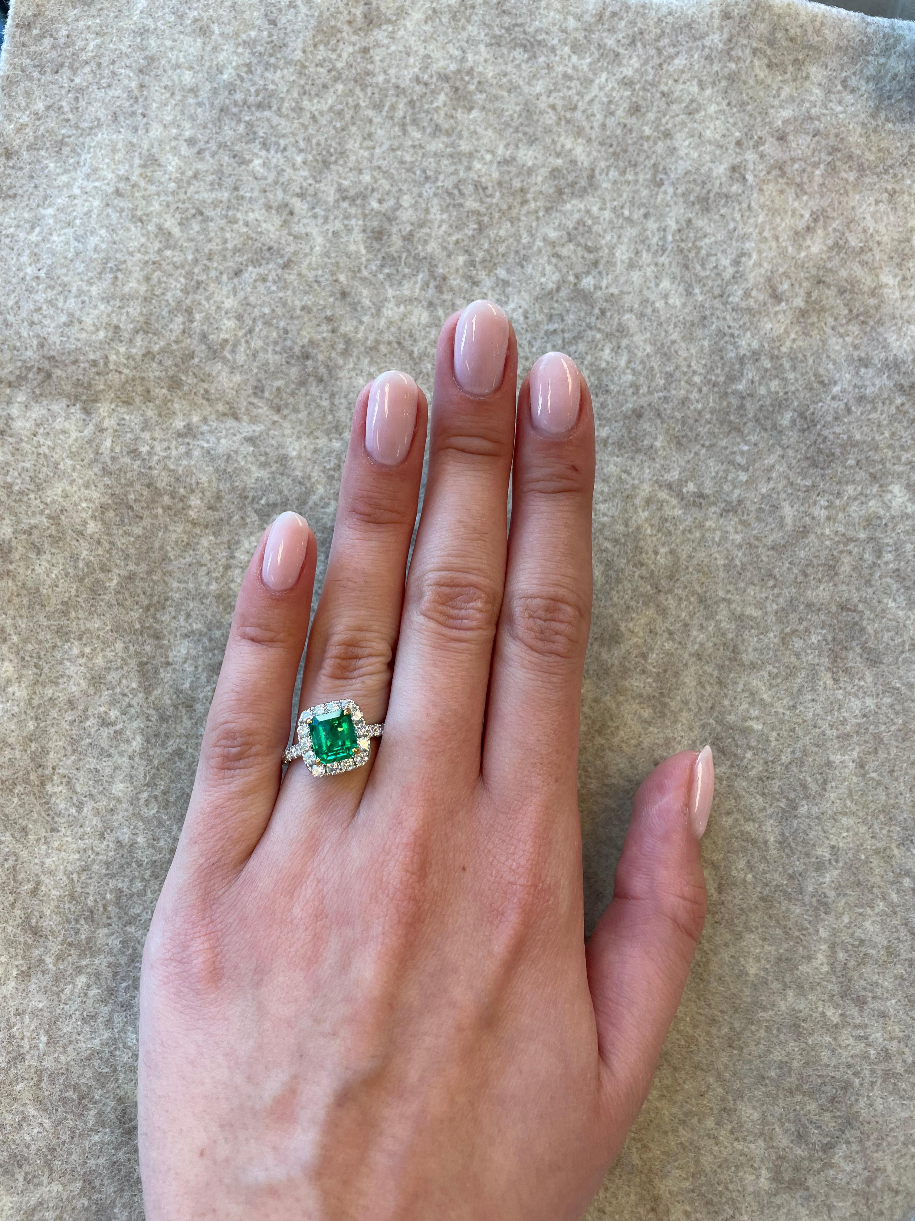 Stunning emerald and diamond halo ring with split shank.
2.56 carats total gemstone weight.
1.68 carat emerald cut emerald, apx F2. Complimented by 26 round brilliant diamonds, 0.88 carats. Approximately G/H color and SI clarity. 18k white gold with