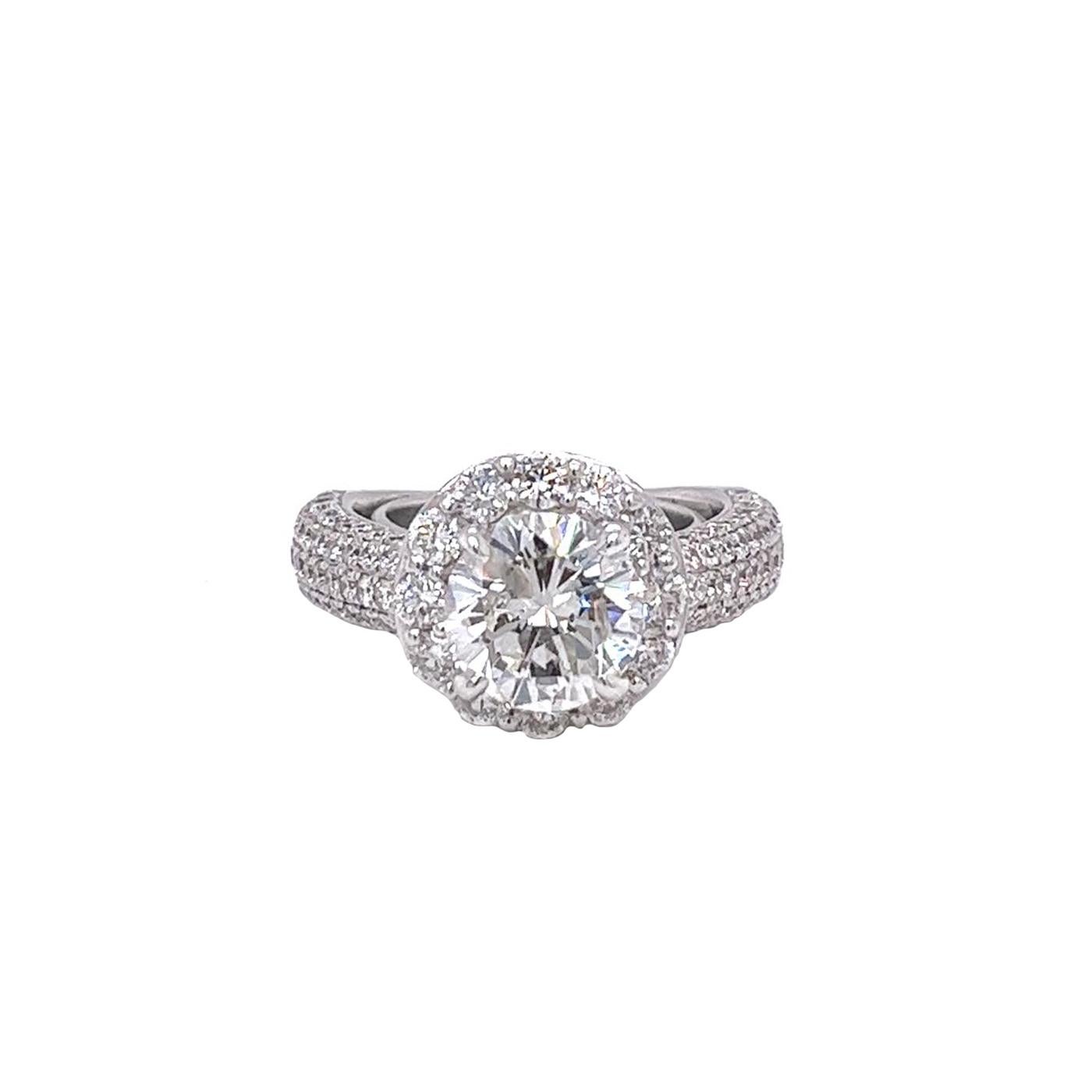 A classic natural diamond engagement ring showcasing a 2.56-carat round-shape cut diamond, H Color, and Si3 in Clarity. Finely Made with 18K White Gold. with 0.75-carat pave round diamonds that feature G color and VS1 clarity. This piece represents