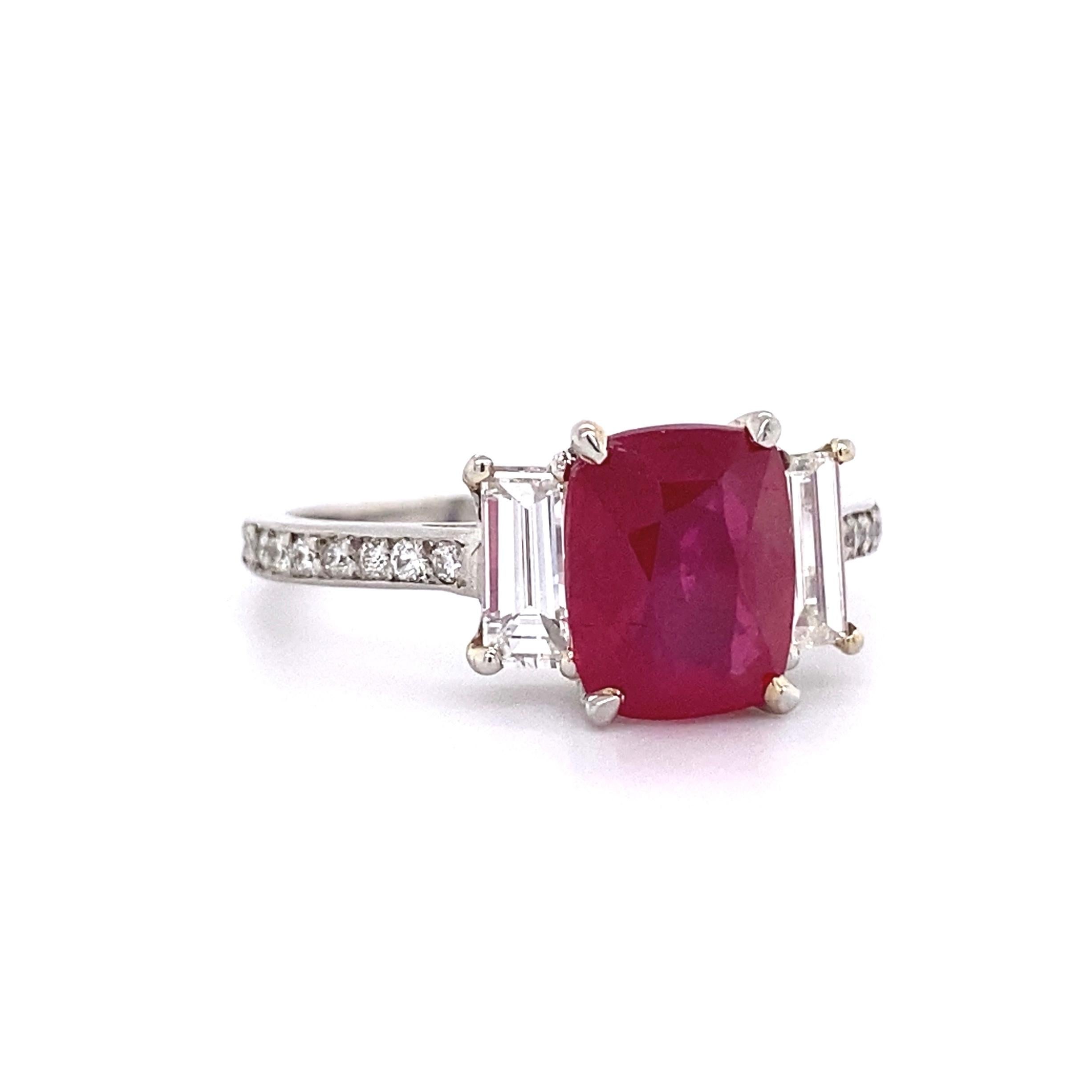 Simply Beautiful! Finely detailed Ruby and Diamond Platinum Ring, centering a Hand set securely nestled 2.57 Carat Cushion Cut Ruby with baguette Diamond on either side and round Diamonds all the way down the shank. Approx. 0.63 total carat weight.