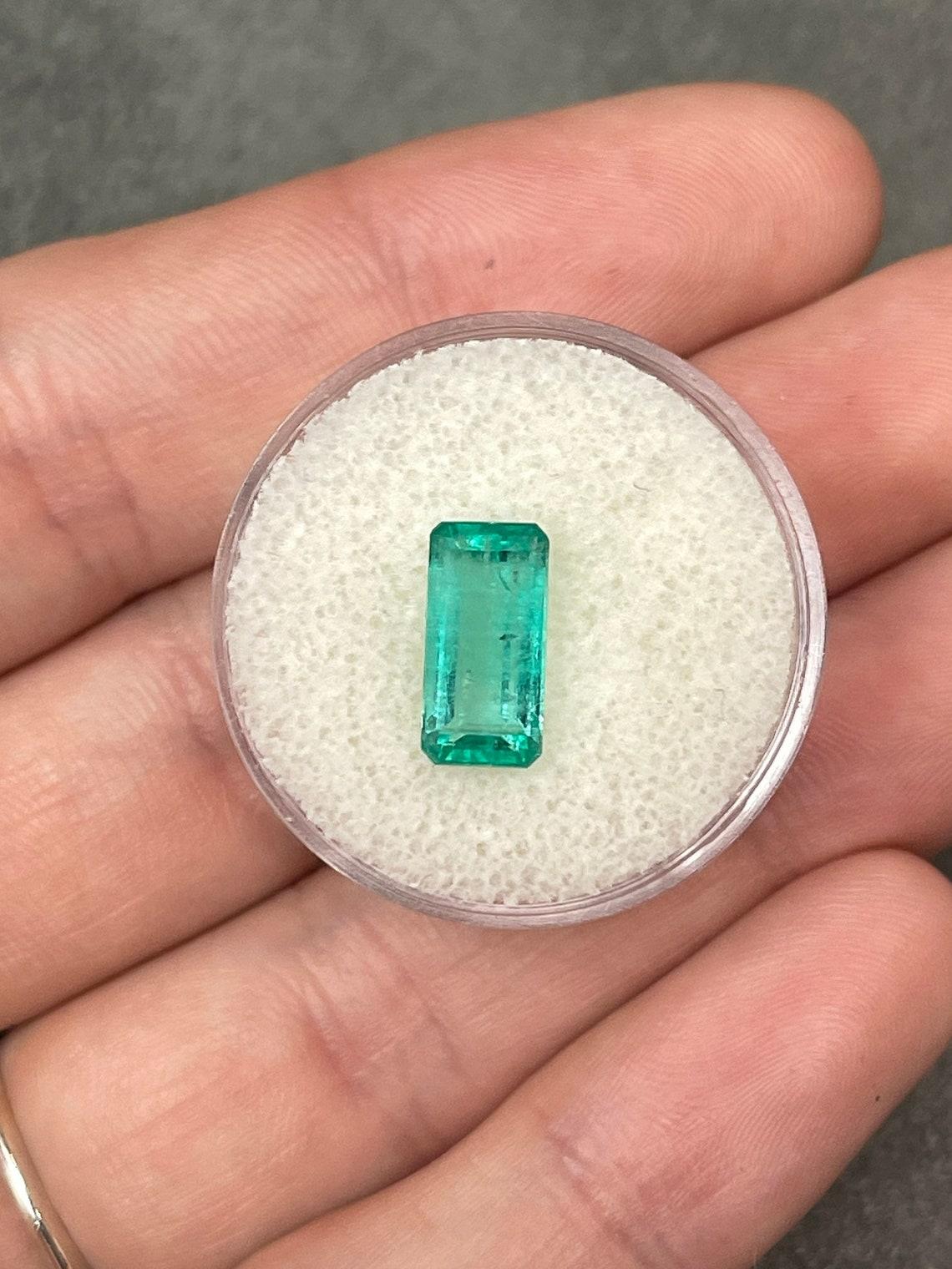 Stone: Emerald
Weight: 2.57-carats
Shape: Emerald Cut
Clarity: Transparent
Luster: Very Good
Color: Light Bluish Green
Measurements: 11.53mm x 5.66mm
Geographic Origin: Colombia
Treatment: Natural, Oiling

Comments: Due to their growth conditions in