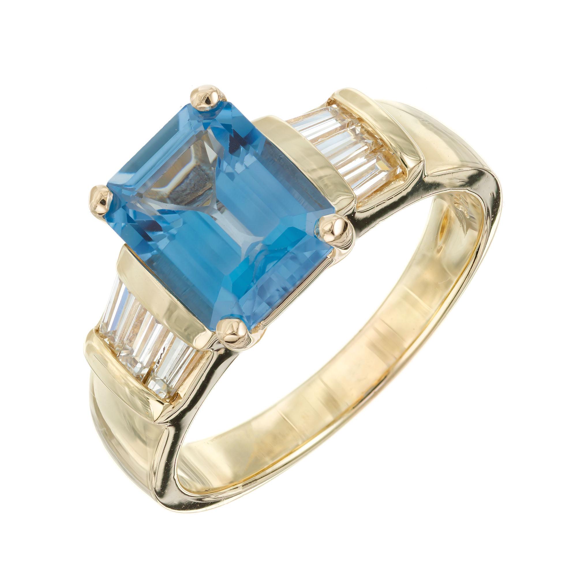 Topaz and diamond right. Bright blue emerald cut 2.50 carat topaz center stone set in a 14k yellow gold setting accented with tapered baguette diamonds.

1 rectangular blue topaz, VS approx. 2.58cts
6 tapered baguettes, H VS approx. .40cts
Size 7