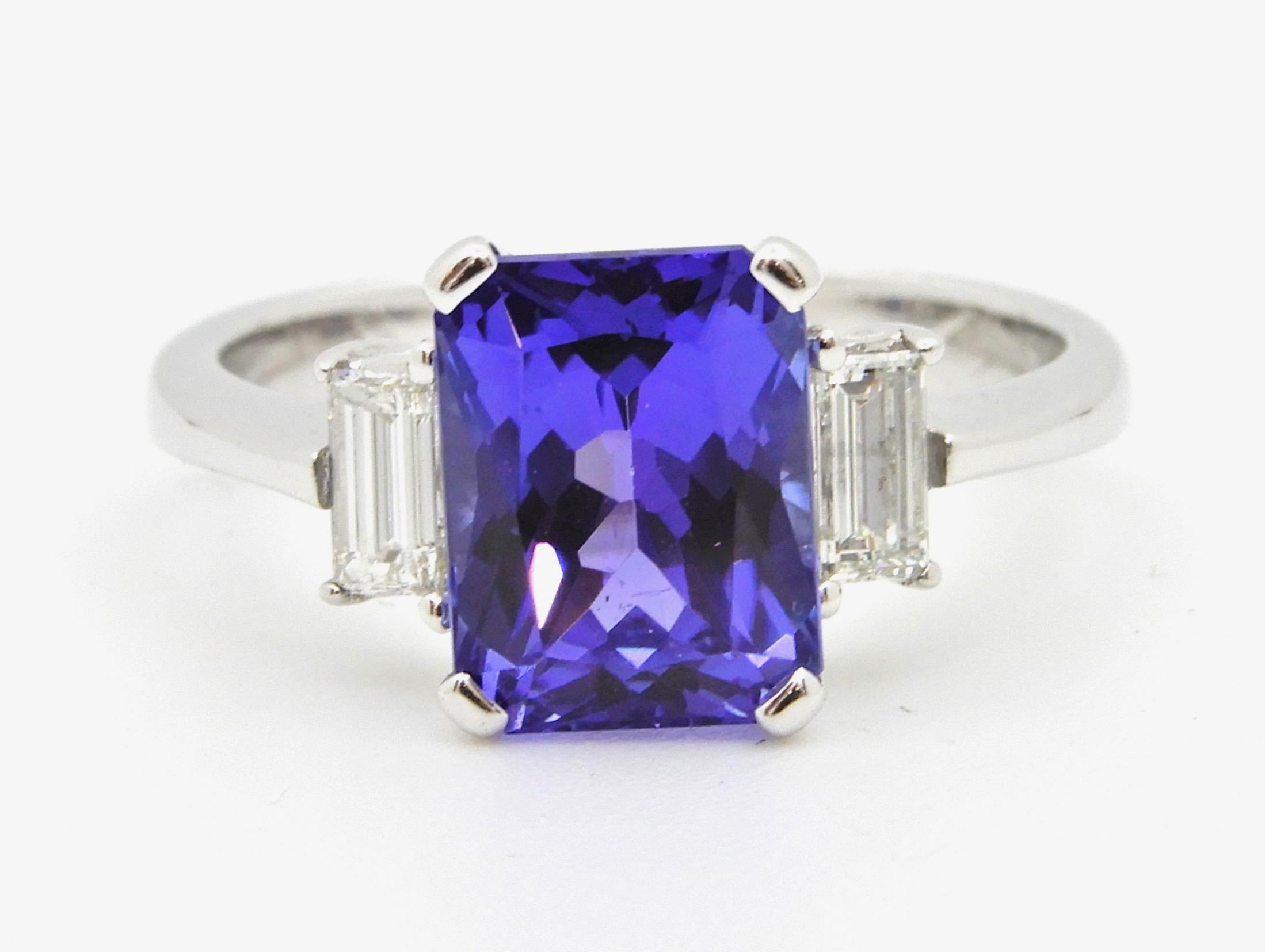This 2.58 Carat Radiant Cut Tanzanite Diamond Cocktail Ring is set in 18 carat Australian White Gold. The has rising shoulders that support a central 4 claw mount, holding one emerald radiant cut Tanzanite, flanked by one claw set baguette cut