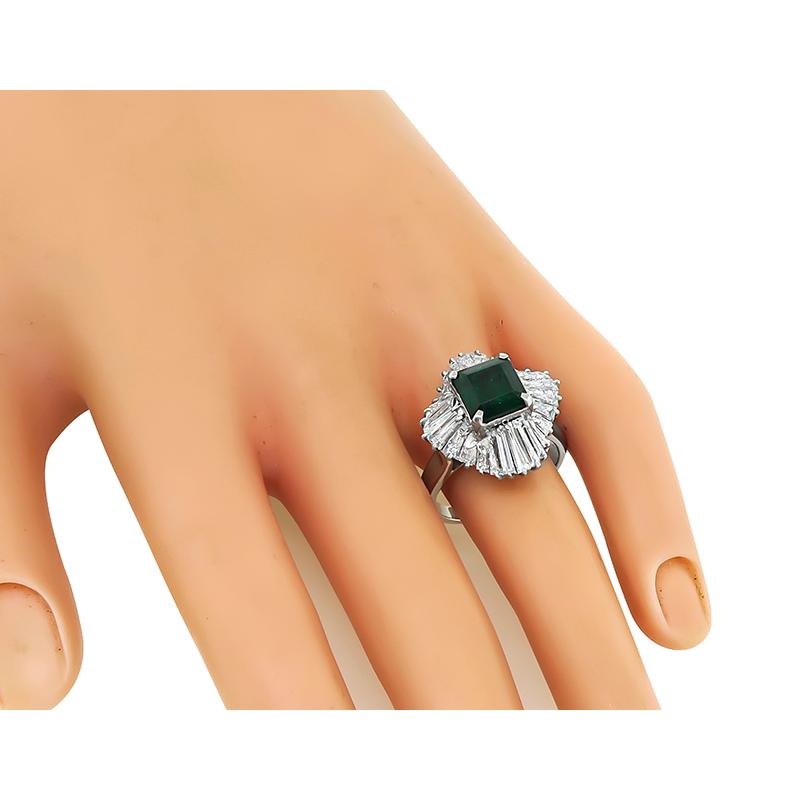 This is a gorgeous platinum ring. The ring is centered with a lovely emerald cut emerald that weighs approximately 2.58ct. The center stone is accentuated by sparkling baguette cut diamonds that weigh approximately 2.30ct. The color of these